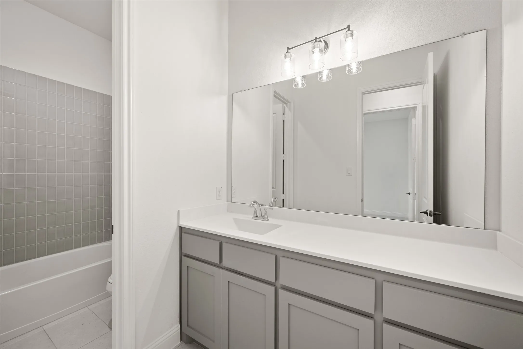 Bathroom featuring vanity, tile patterned floors, and shower / bath combination