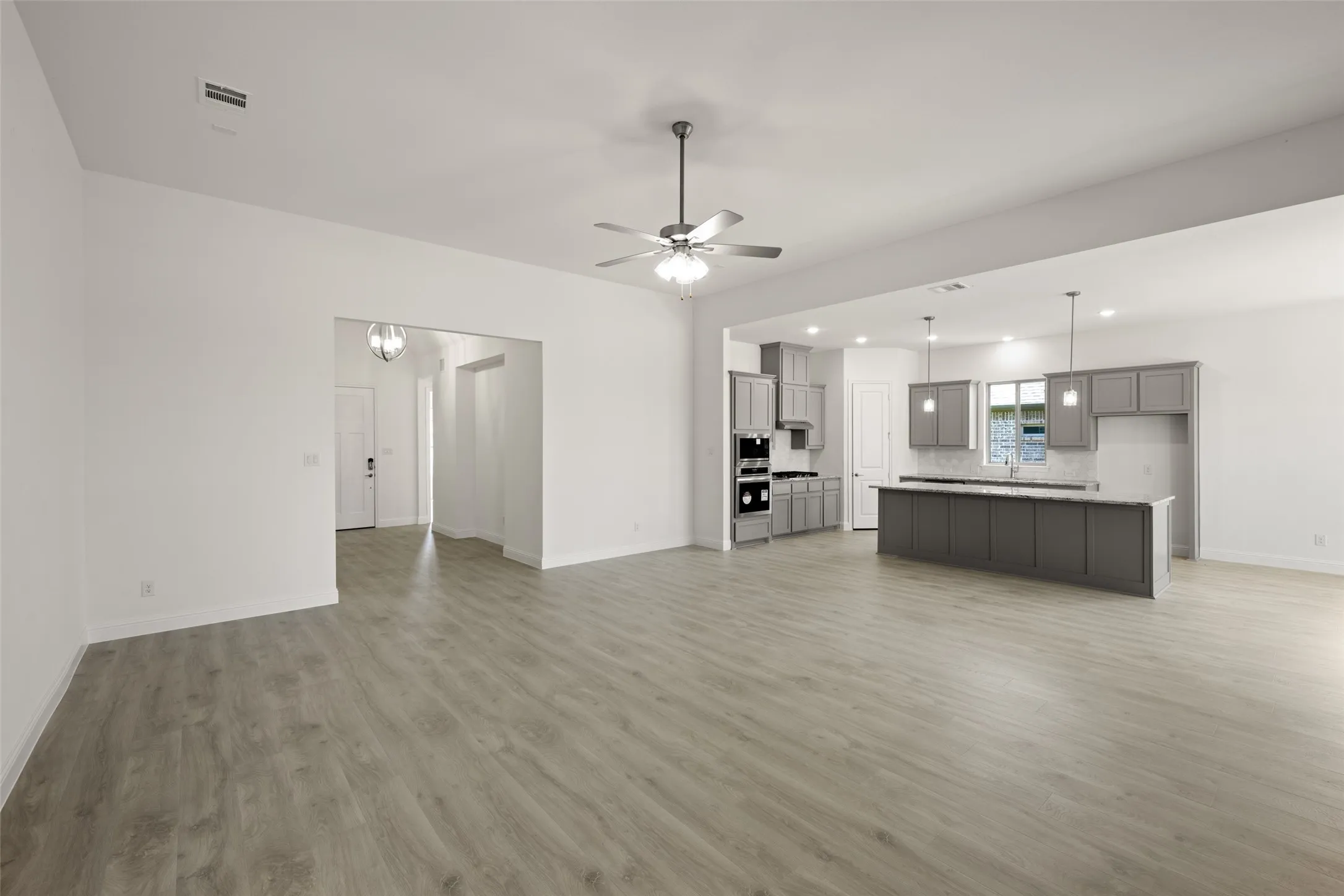 Unfurnished living room featuring light wood-style flooring, ceiling fan, and recessed lighting