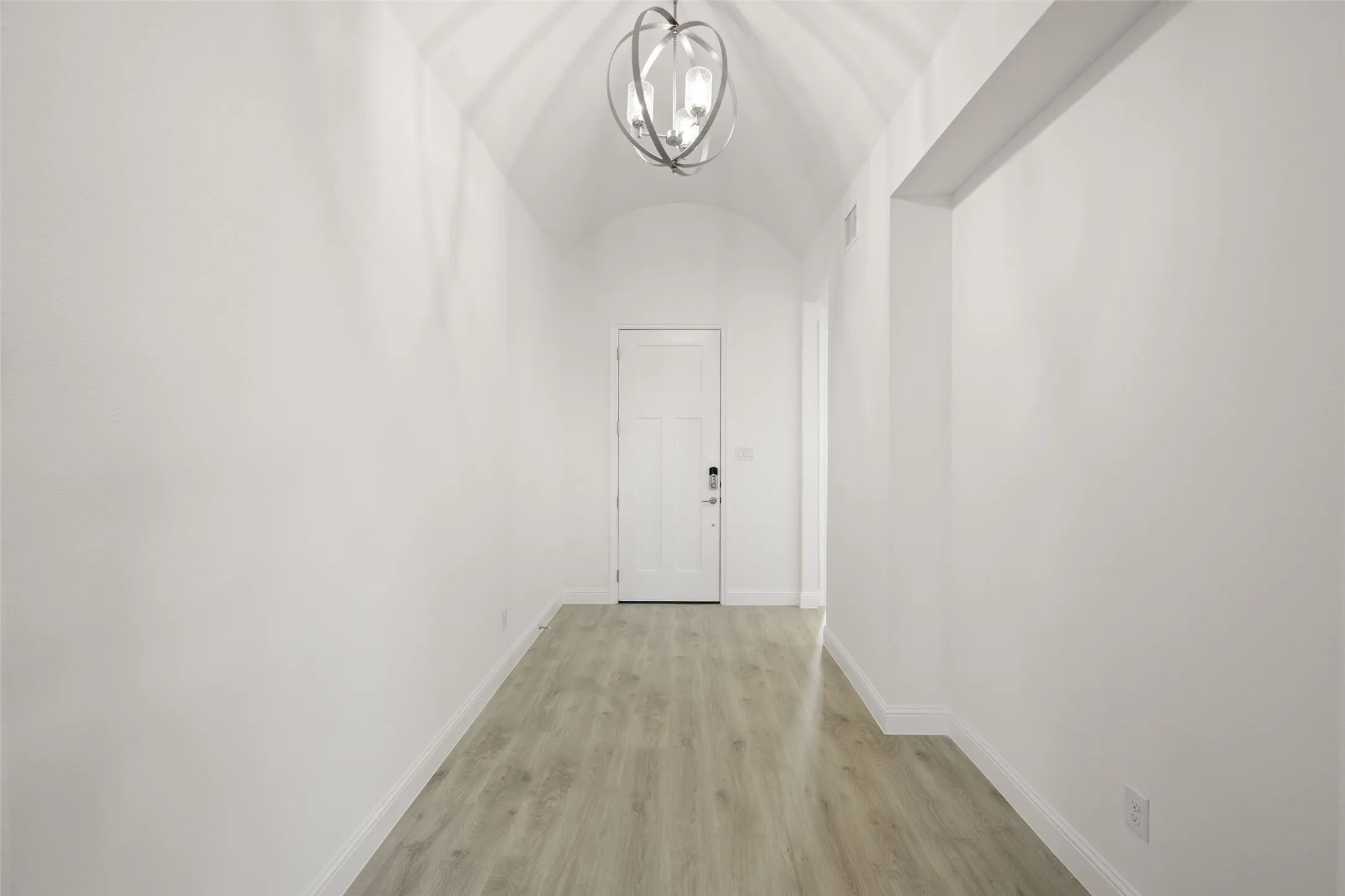 Hallway featuring a chandelier and light wood-type flooring