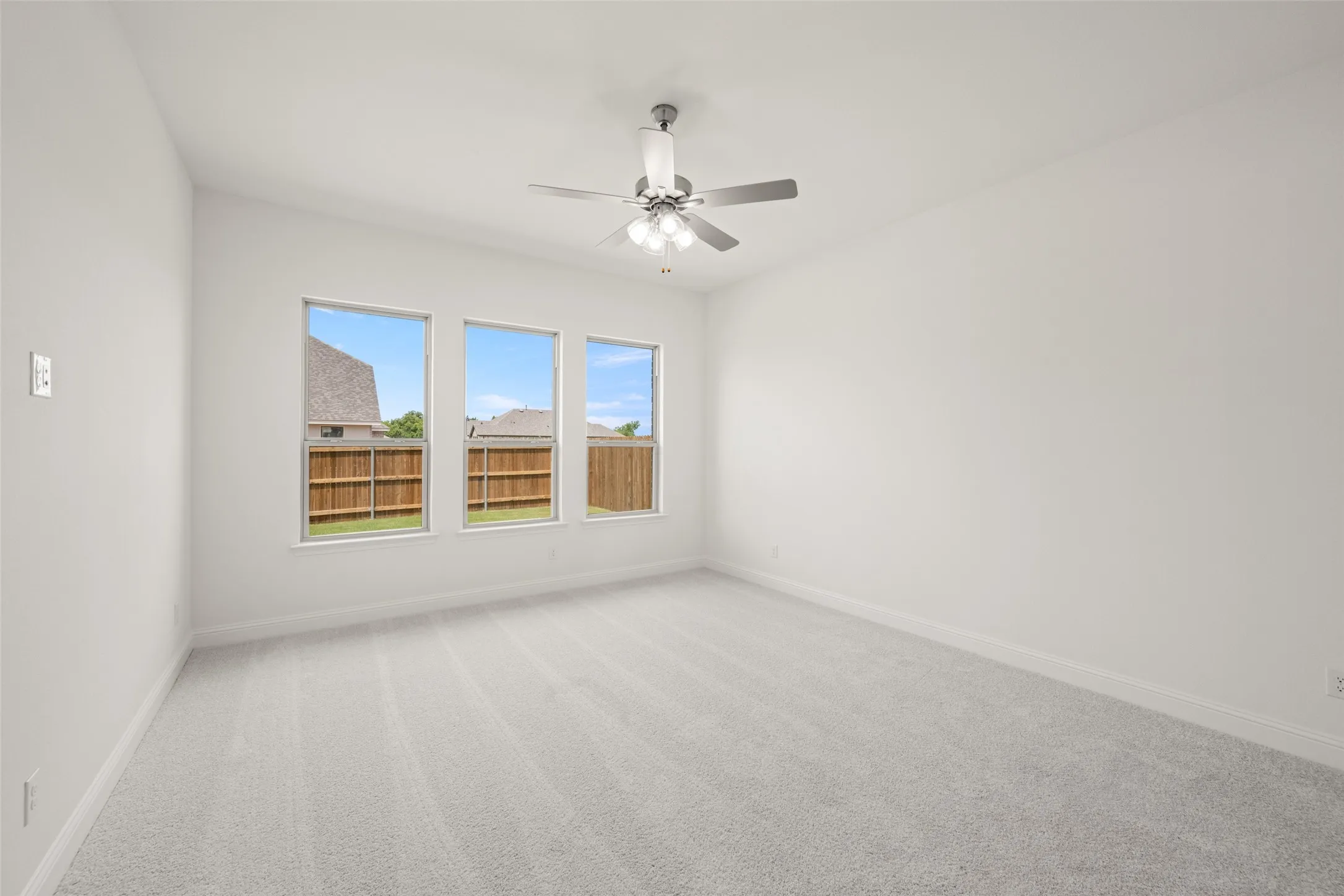 Unfurnished room featuring light colored carpet and ceiling fan