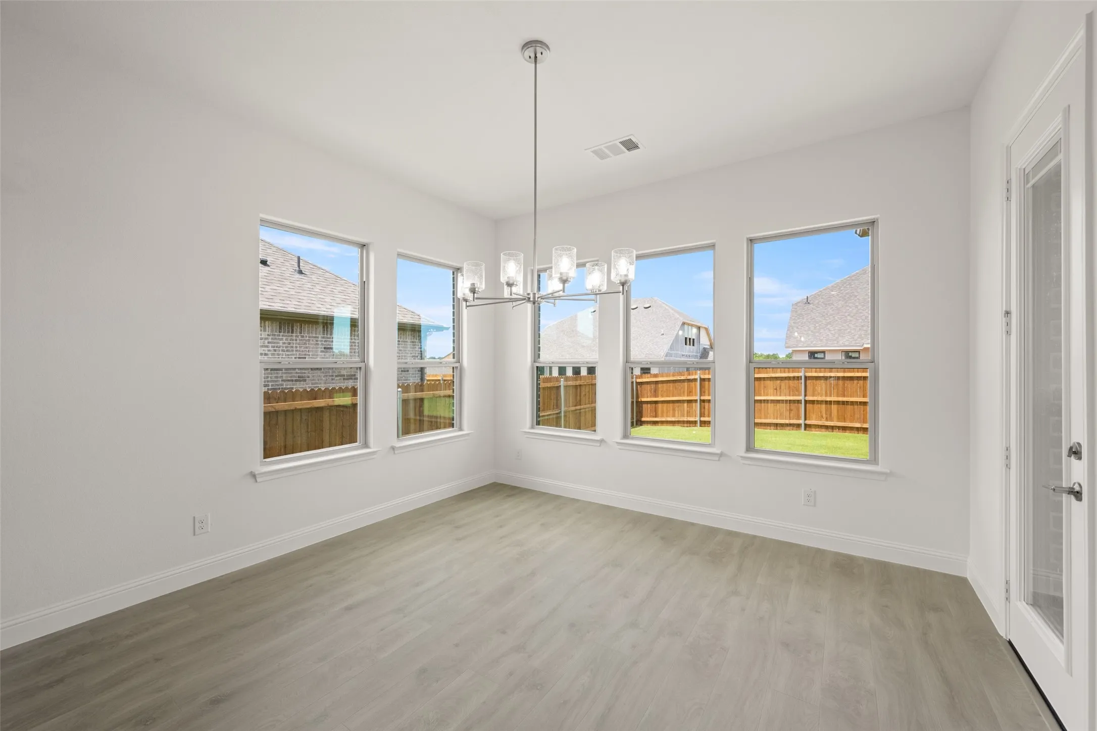 Unfurnished dining area featuring a chandelier and light wood finished floors
