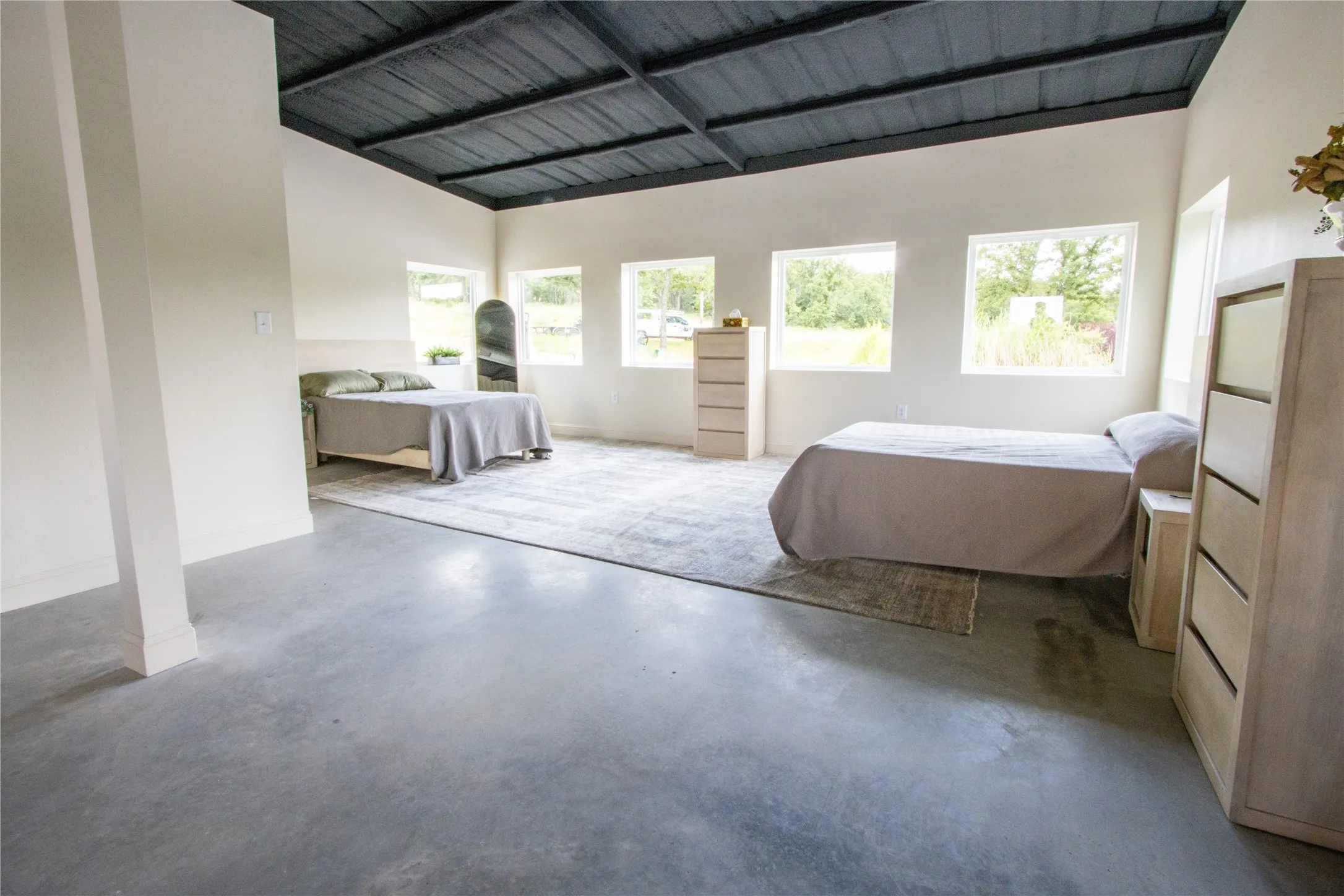 Bedroom with concrete floors and high vaulted ceiling