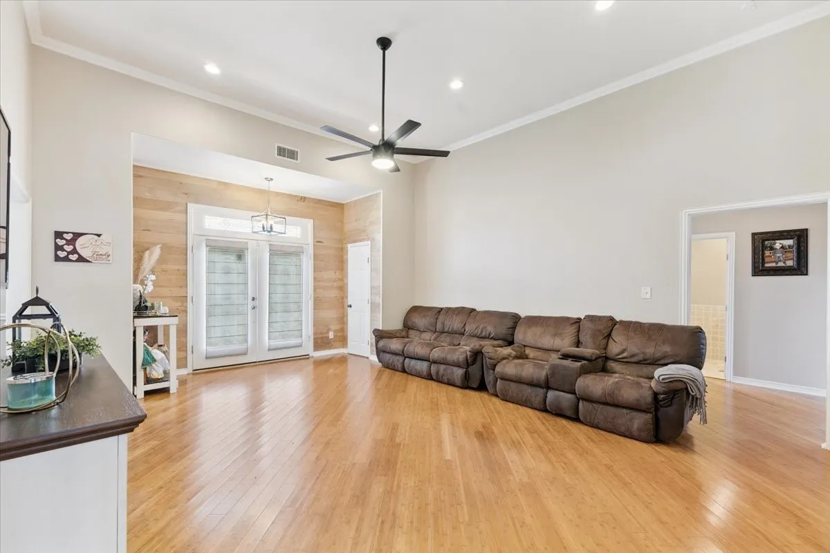 Living area with light wood finished floors, a ceiling fan, recessed lighting, and ornamental molding