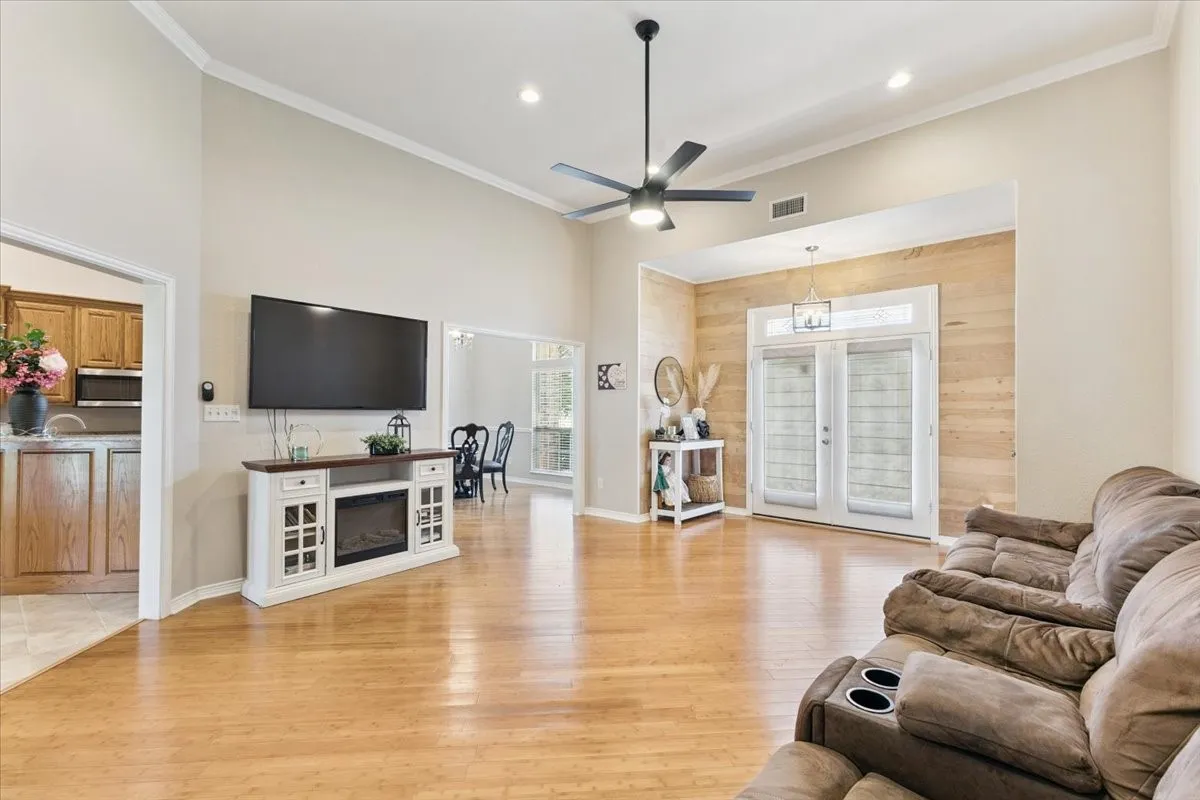Living area with light wood-type flooring, ceiling fan, crown molding, recessed lighting, and french doors