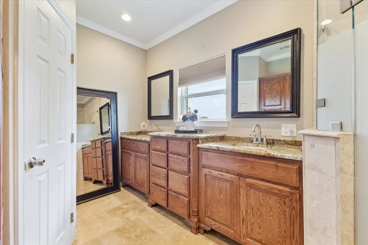 Full bathroom featuring crown molding and double vanity