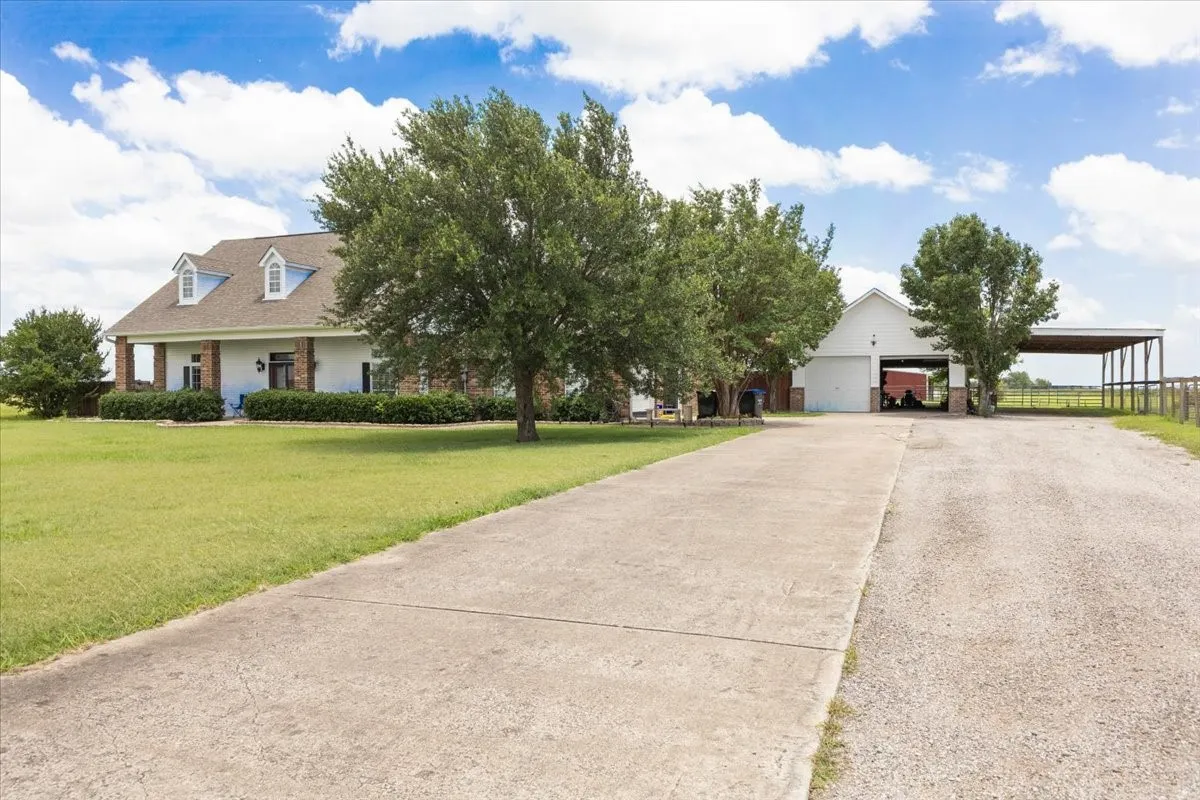 View of front of home with a carport, concrete driveway, a front yard, and brick siding