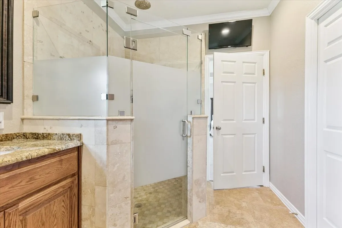 Bathroom with vanity, a stall shower, and crown molding