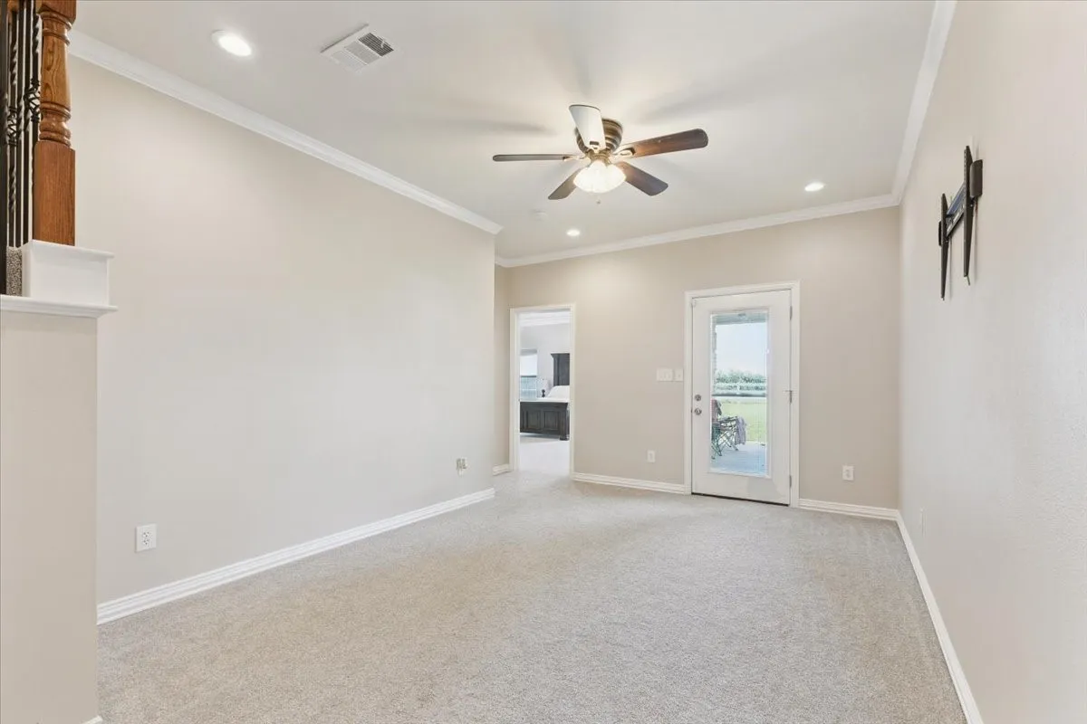 Empty room with ceiling fan, light colored carpet, crown molding, and recessed lighting