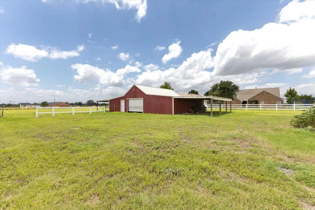 View of yard featuring a pole building, a garage, and an outbuilding
