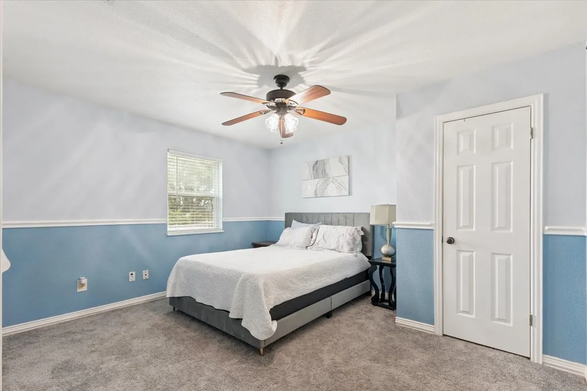 Bedroom with carpet floors and a ceiling fan