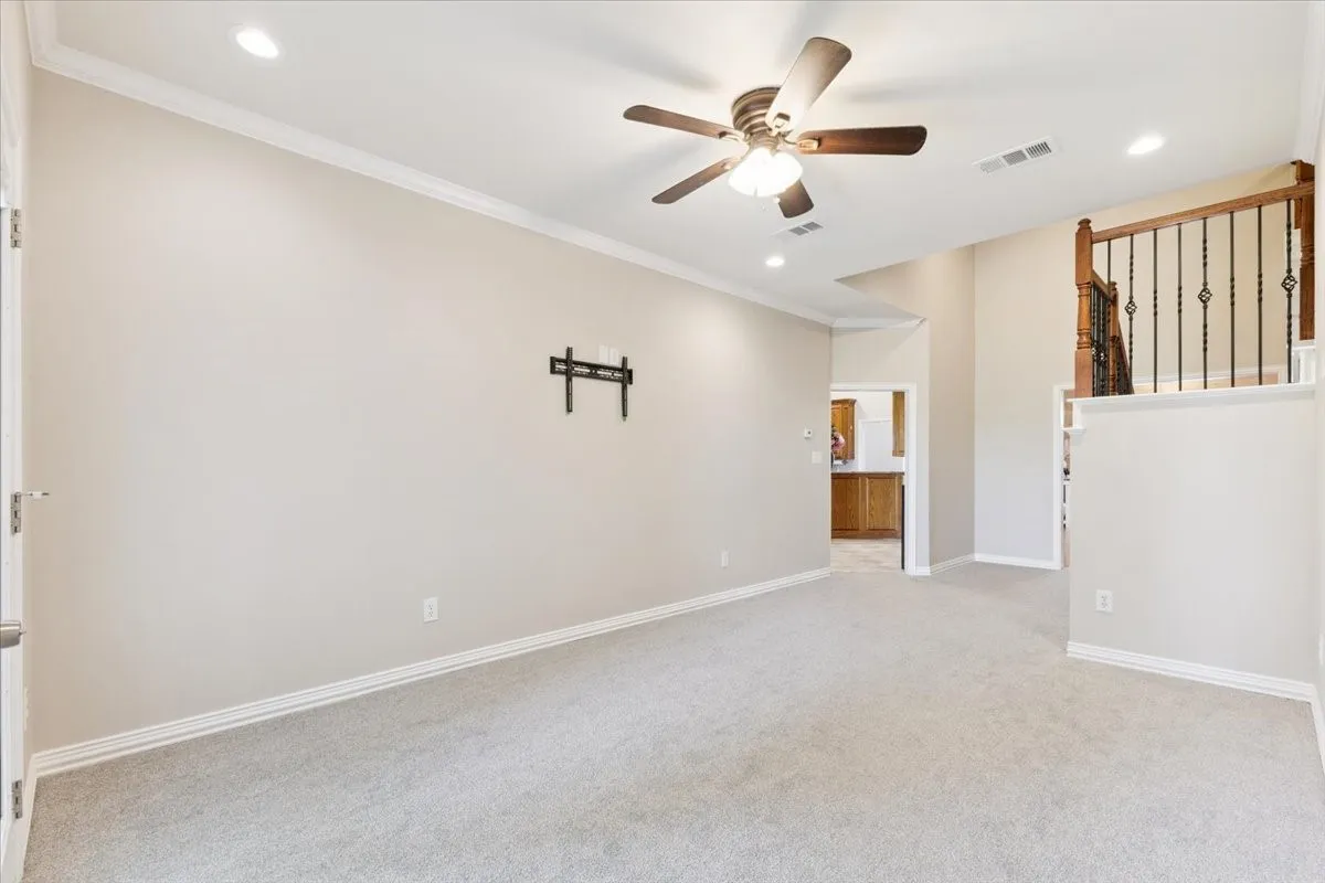 Unfurnished room featuring ceiling fan, light carpet, recessed lighting, and ornamental molding
