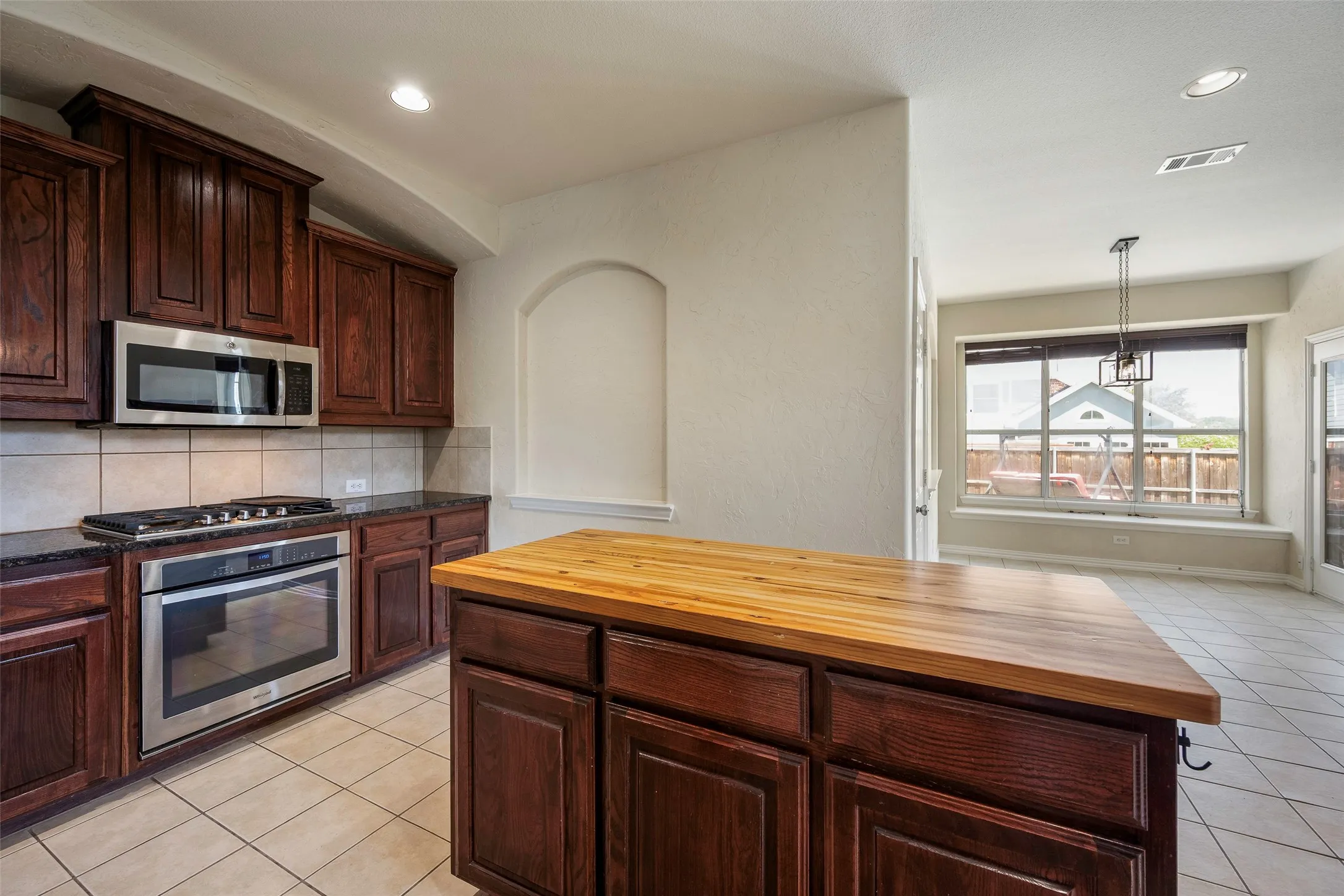 Gas cooktop and stove, and a custom handmade oak countertop on the kitchen island!