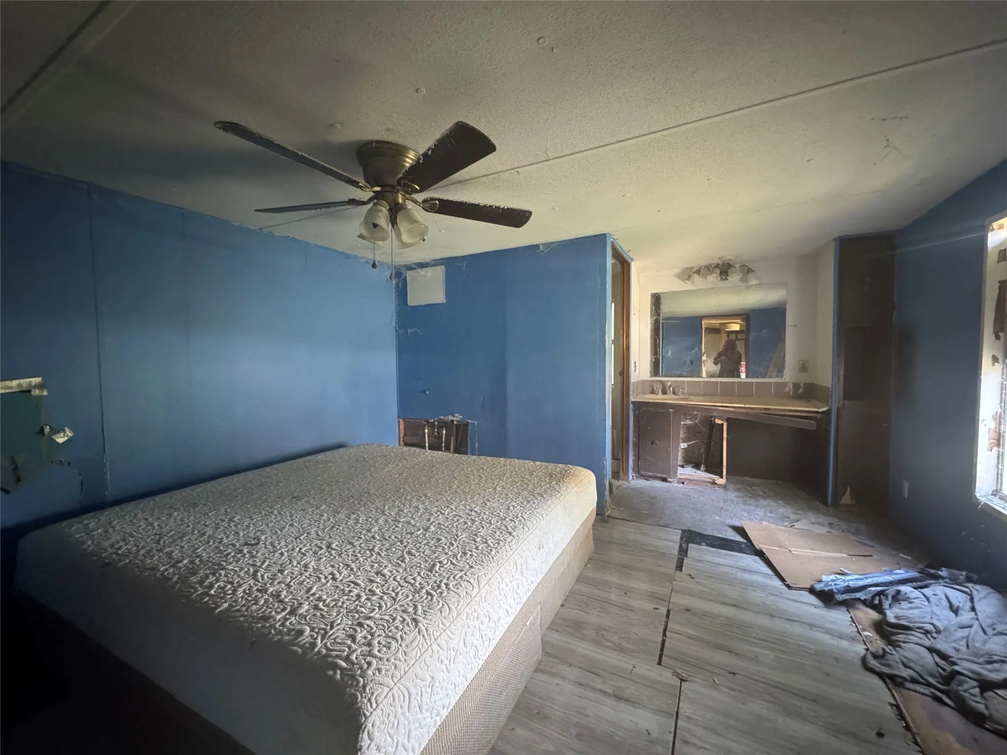 Bedroom with wood finished floors, ceiling fan, and a textured ceiling