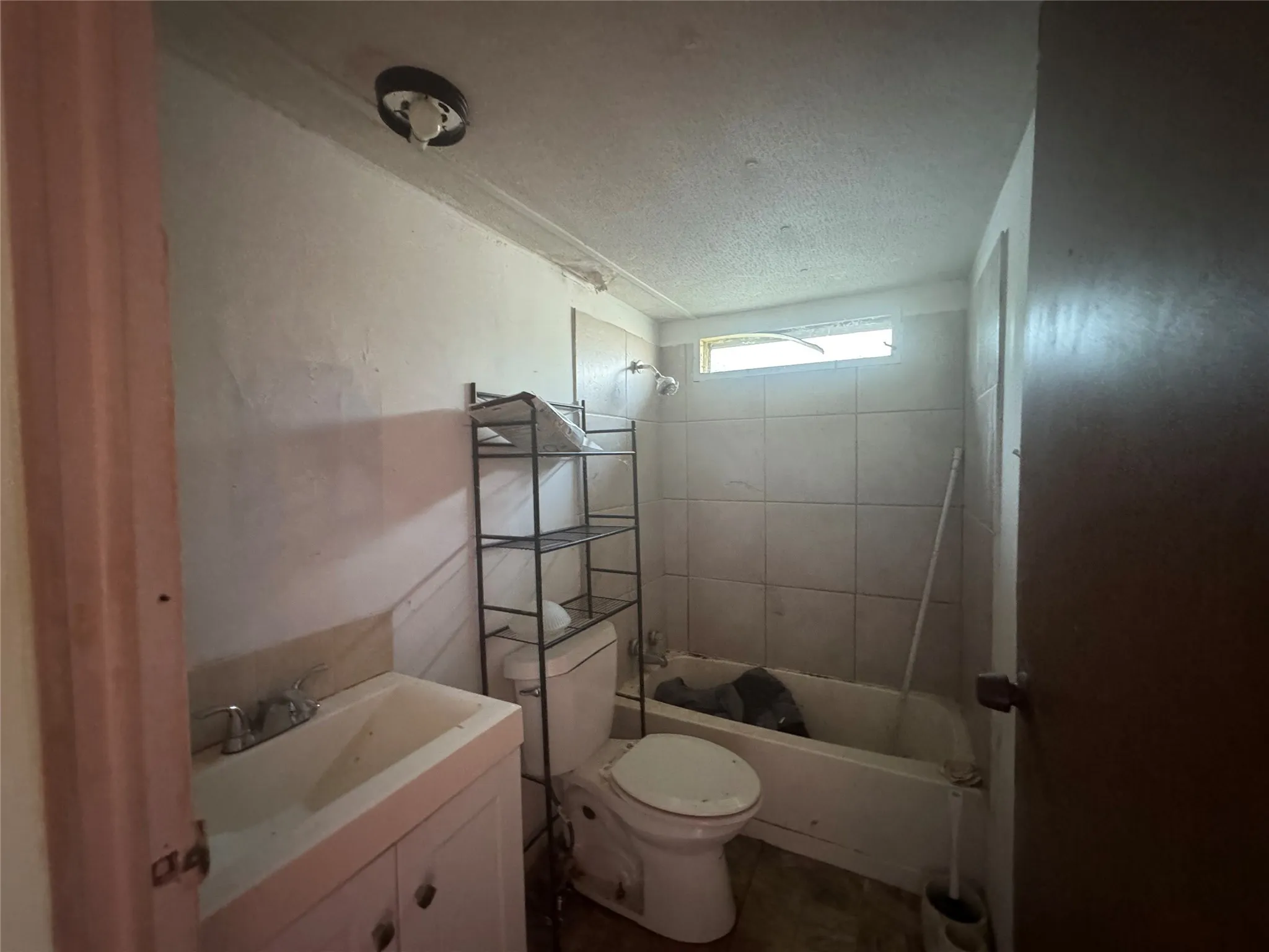 Bathroom featuring shower / washtub combination, vanity, and a textured ceiling