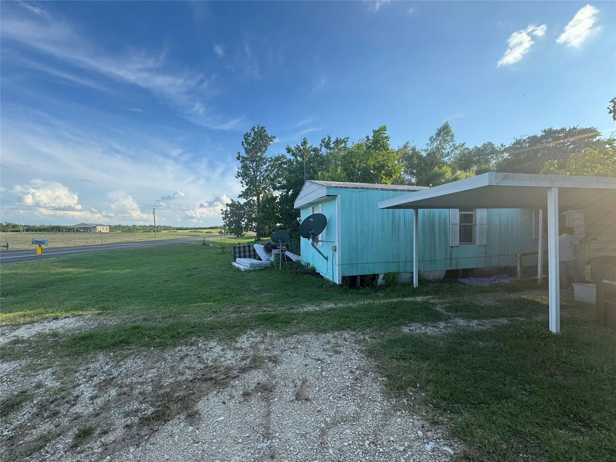 View of green lawn featuring a carport