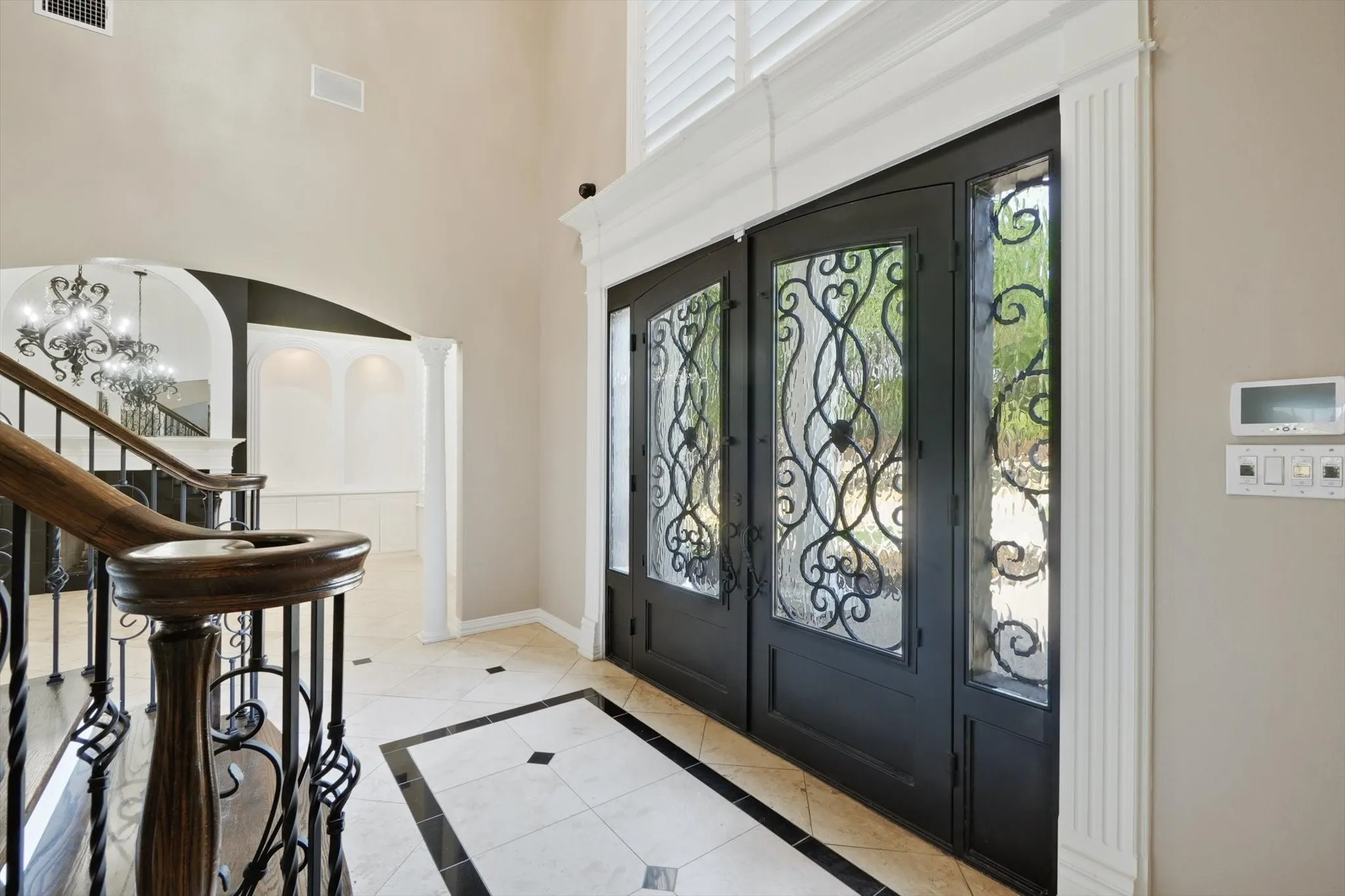 Foyer featuring french doors, a chandelier, light tile patterned floors, stairs, and arched walkways