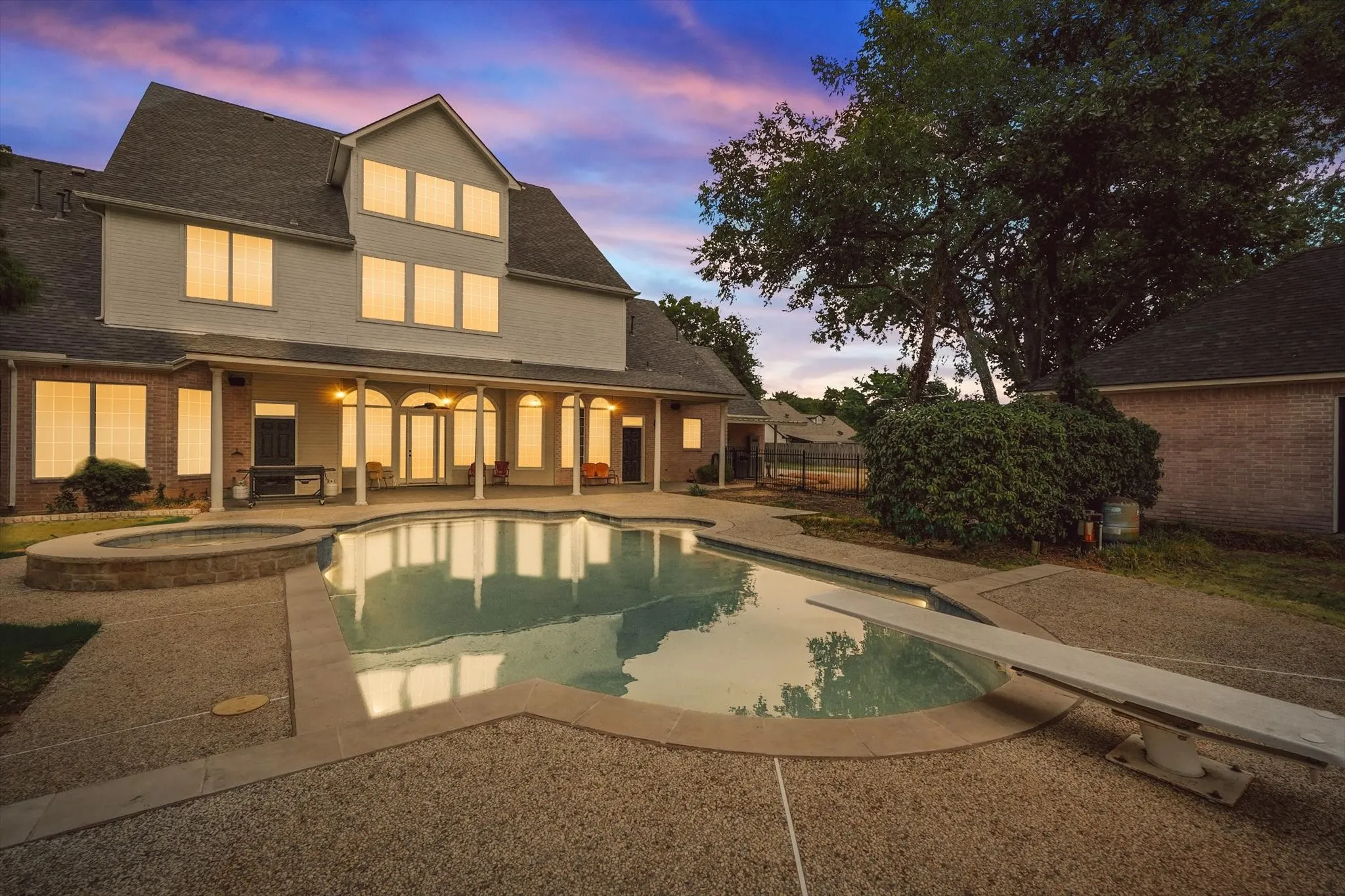 View of pool with a patio, a diving board, and a pool with connected hot tub