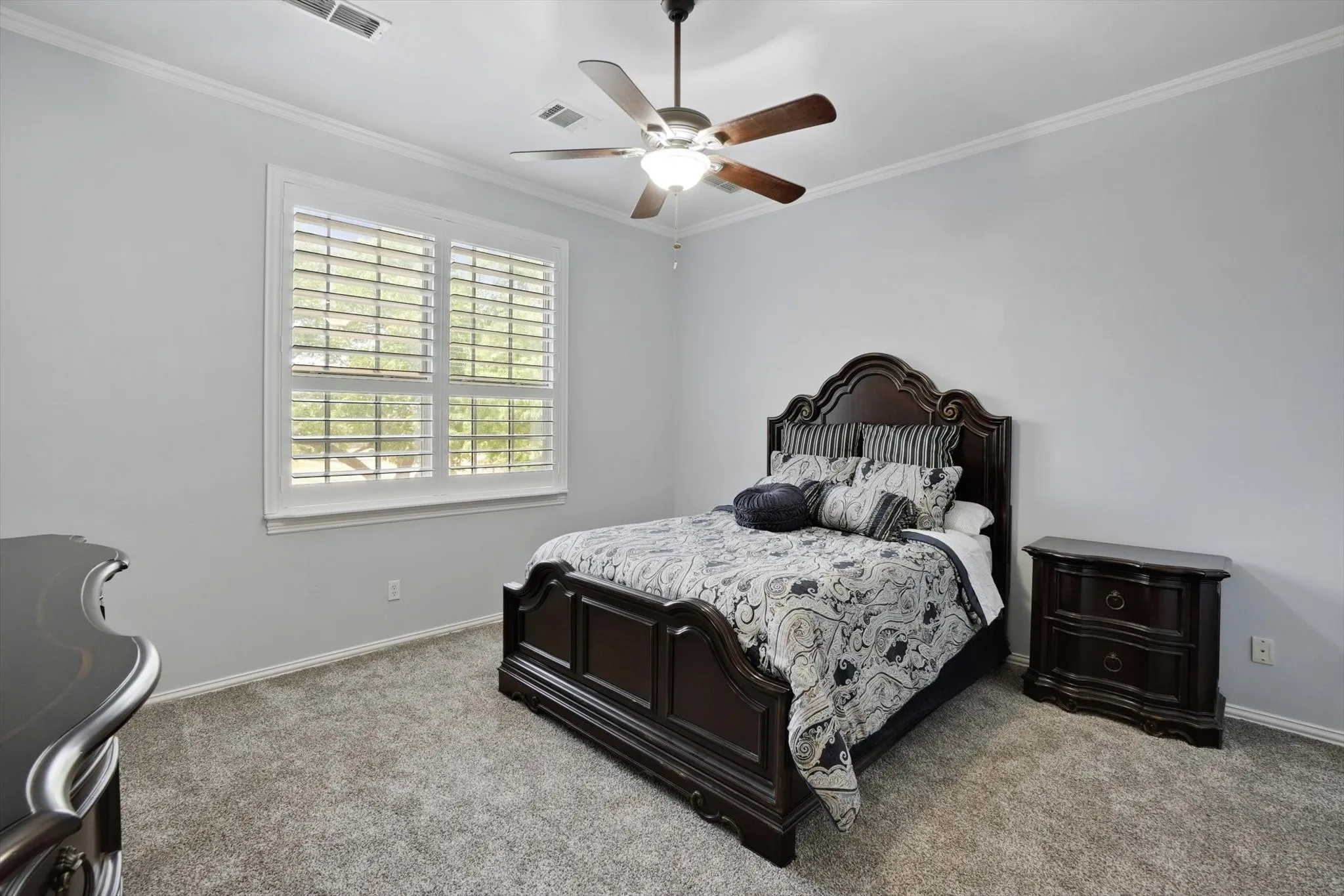 Bedroom featuring carpet, ornamental molding, and ceiling fan
