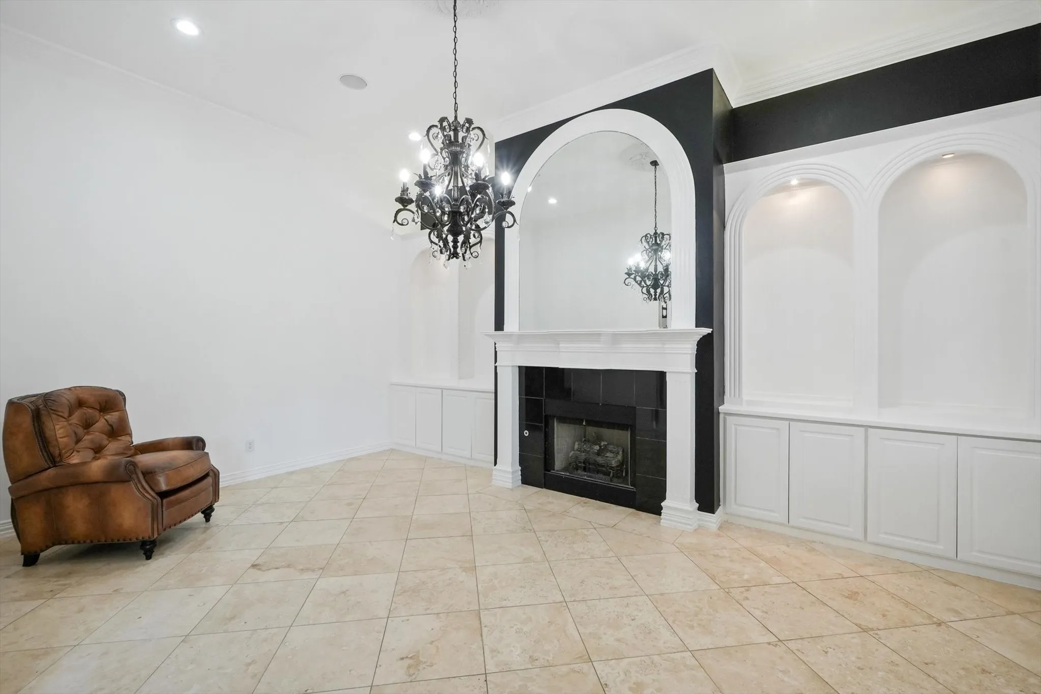 Unfurnished living room featuring a chandelier, a tile fireplace, crown molding, and recessed lighting