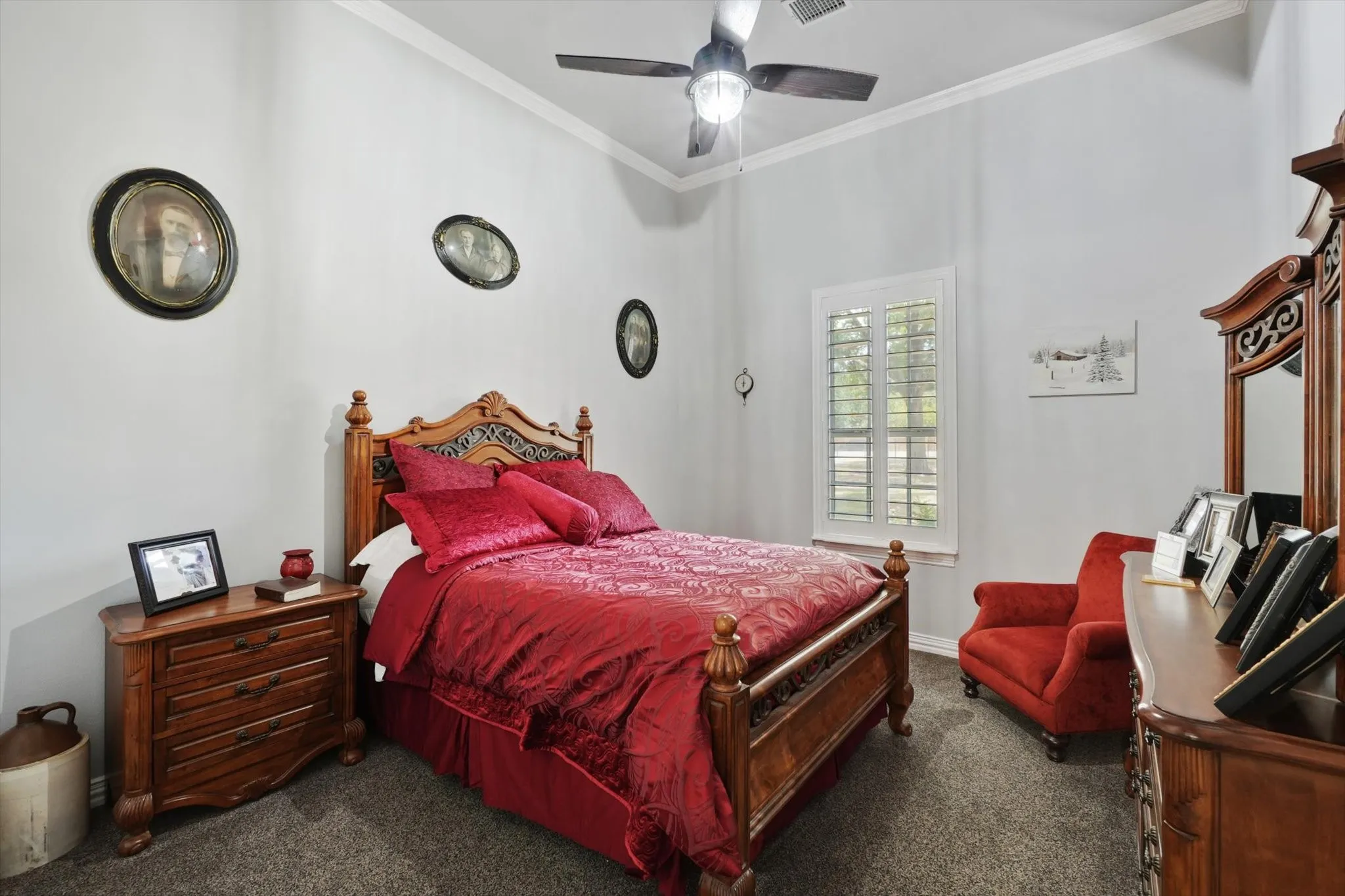 Carpeted bedroom featuring crown molding and ceiling fan