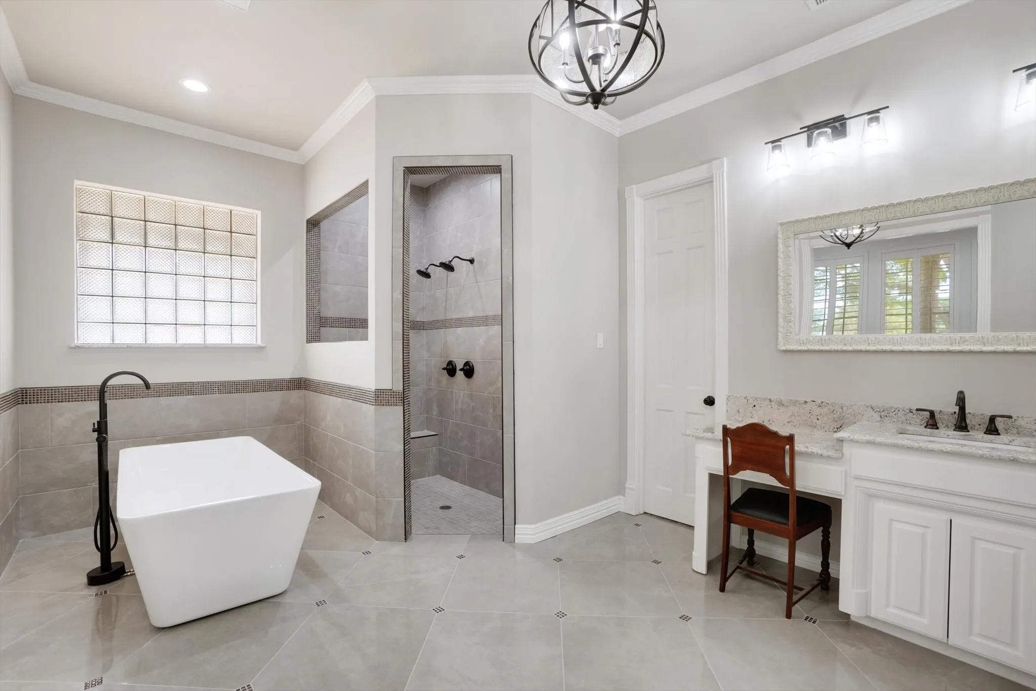 Bathroom featuring a walk in shower, a freestanding bath, crown molding, a chandelier, and vanity