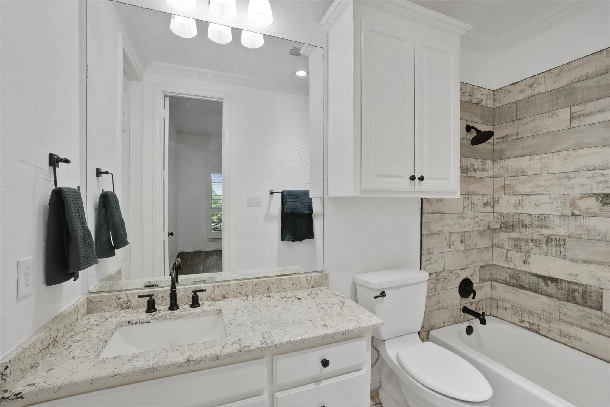 Full bathroom featuring vanity, shower / washtub combination, and ornamental molding