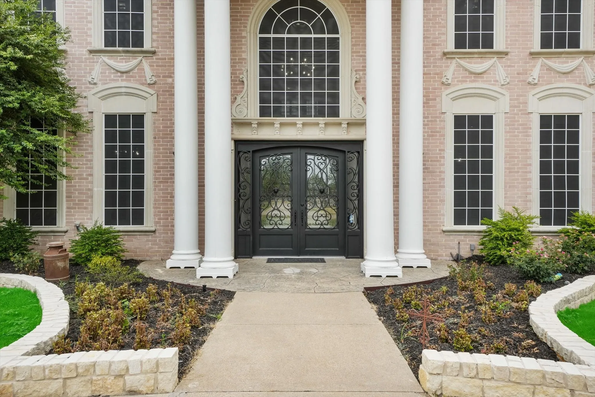 View of exterior entry featuring french doors and brick siding