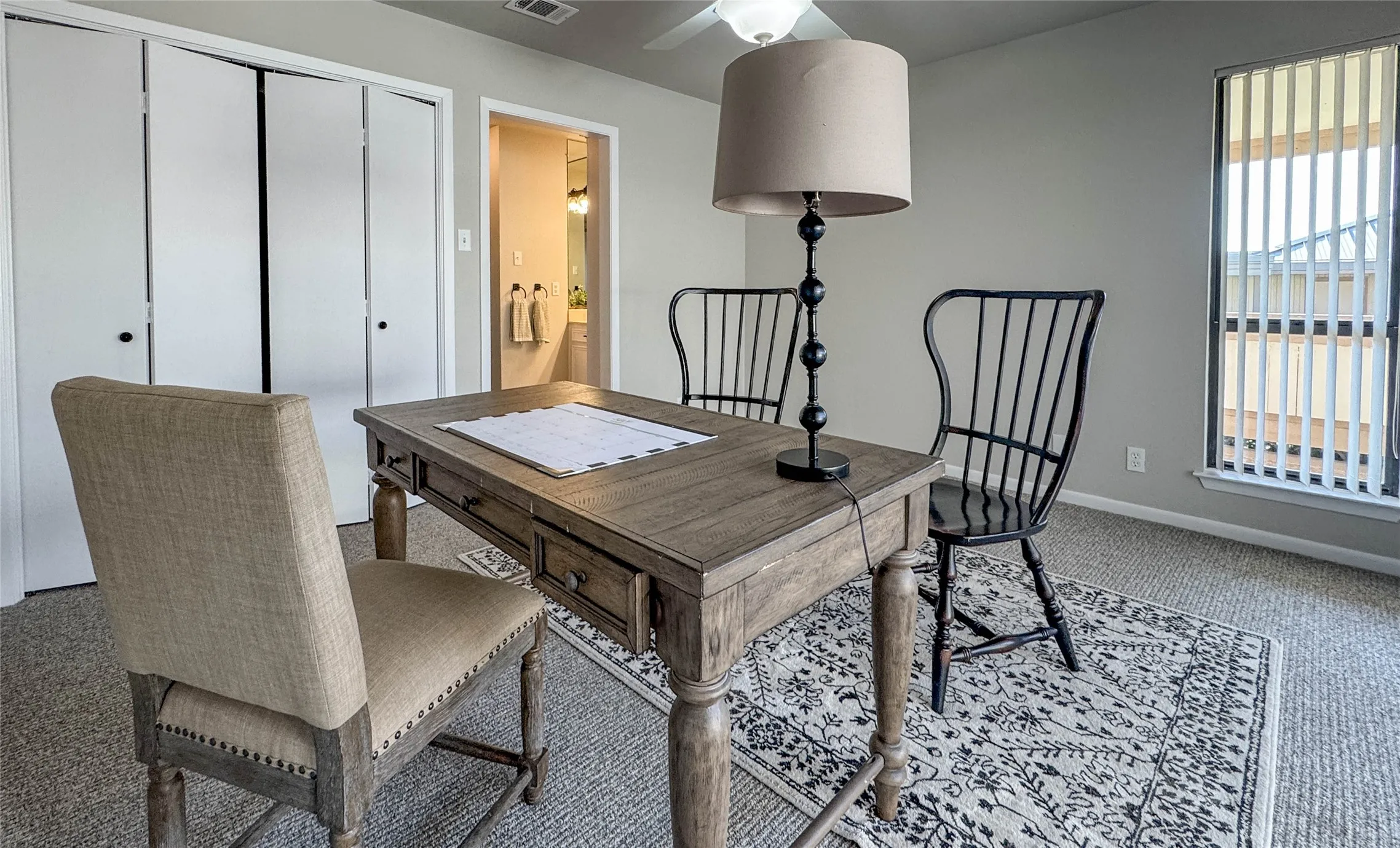 Office with carpet flooring and a ceiling fan