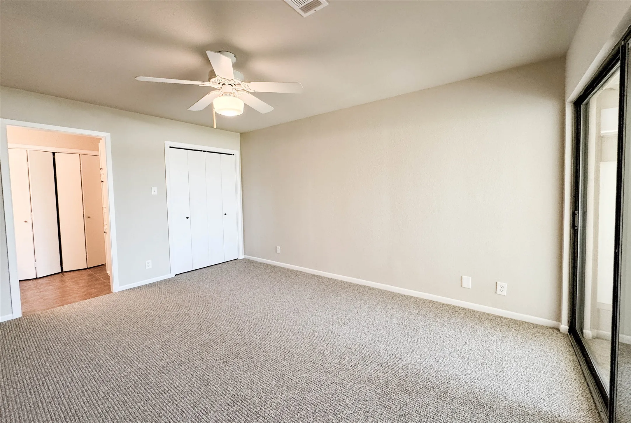 Unfurnished bedroom with carpet floors and ceiling fan