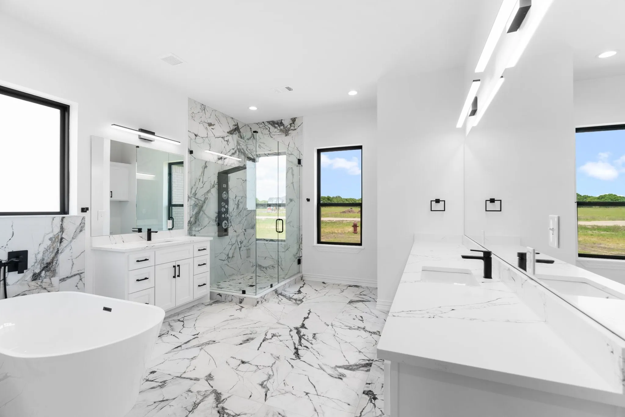 Bathroom featuring a marble finish shower, double vanity, a soaking tub, recessed lighting, and marble tiled floors