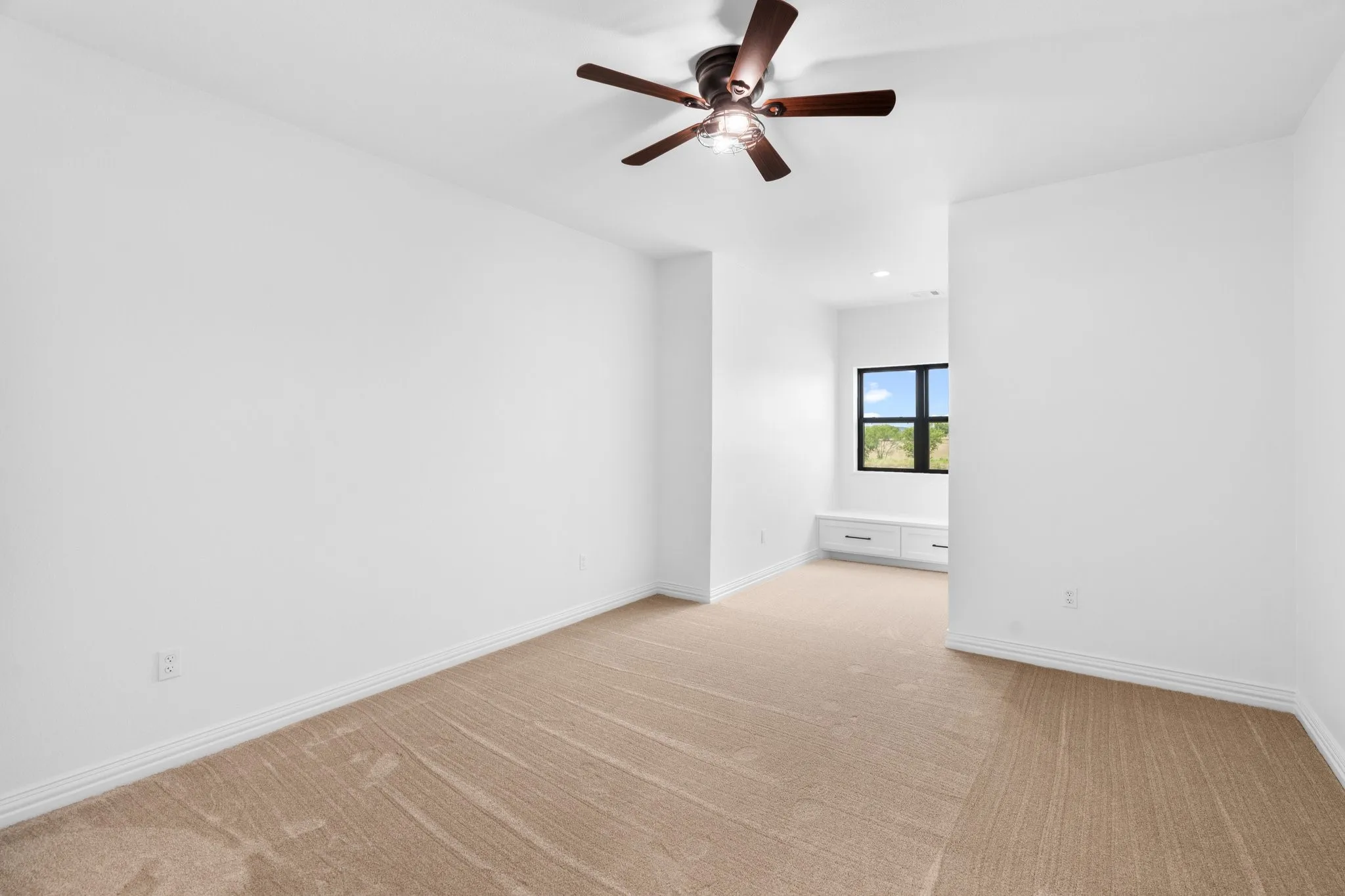 Spare room with light colored carpet and a ceiling fan