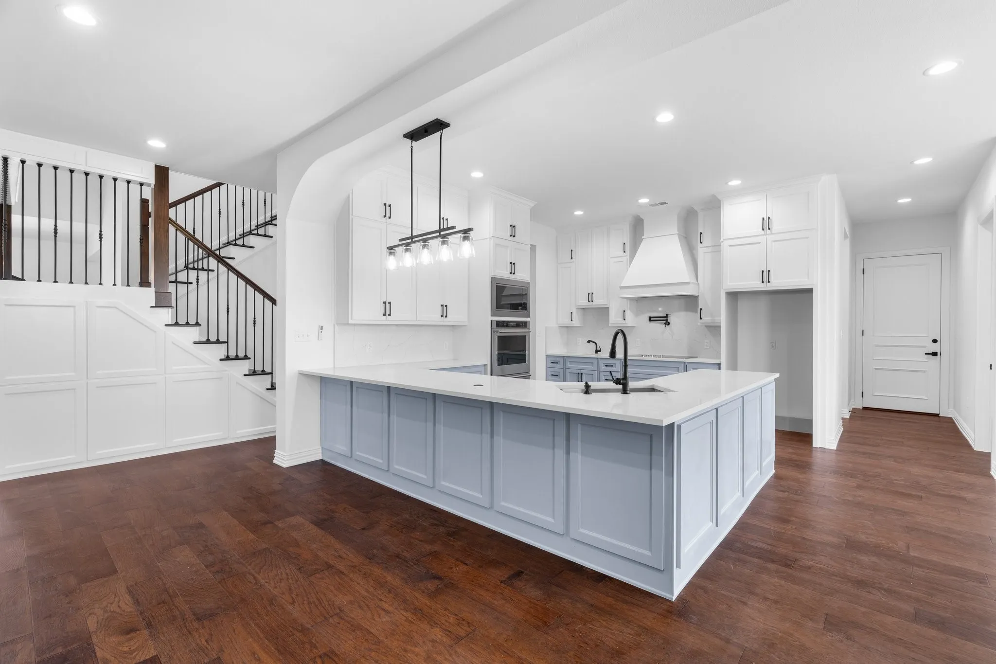 Stairs with wood finished floors, recessed lighting, and a chandelier
