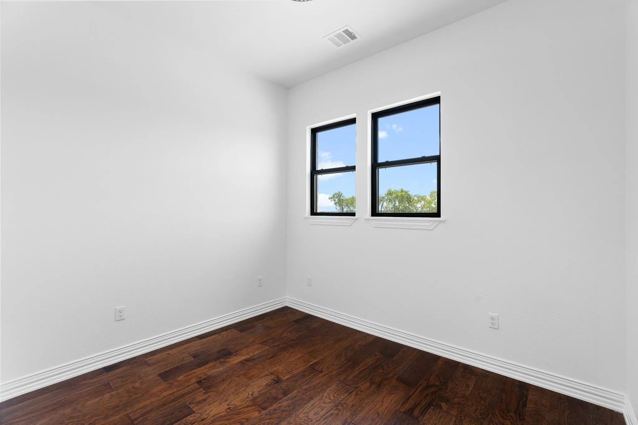 Empty room with baseboards and dark wood finished floors