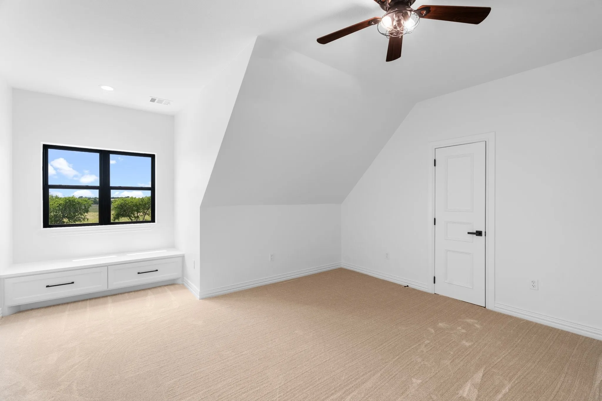 Bonus room featuring light carpet, lofted ceiling, and ceiling fan
