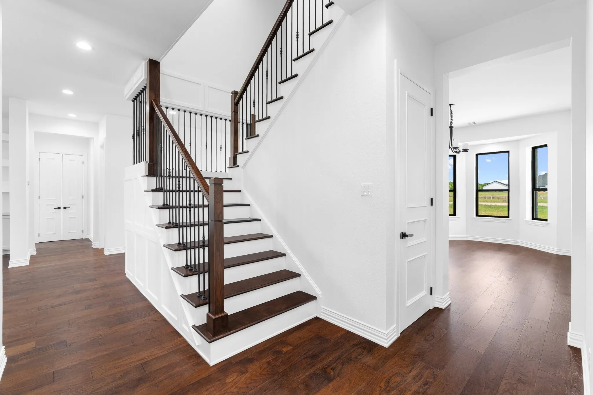 Stairs with wood finished floors, recessed lighting, and a chandelier