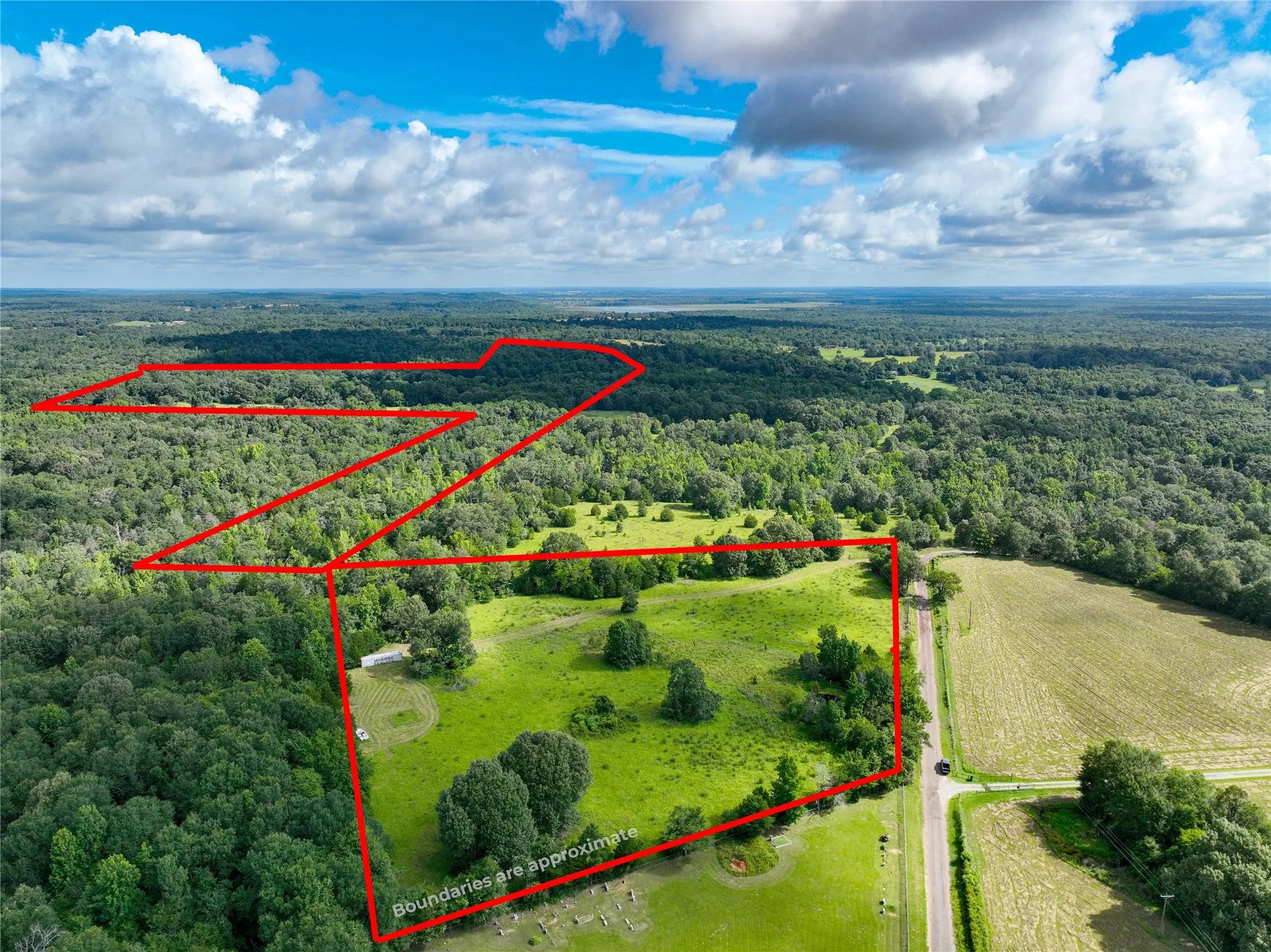 Aerial view of property's location featuring a forest and property parcel outlined