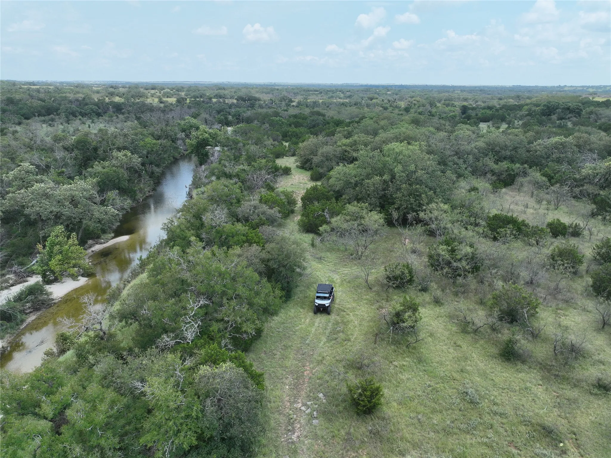Aerial view of property's location featuring a forest