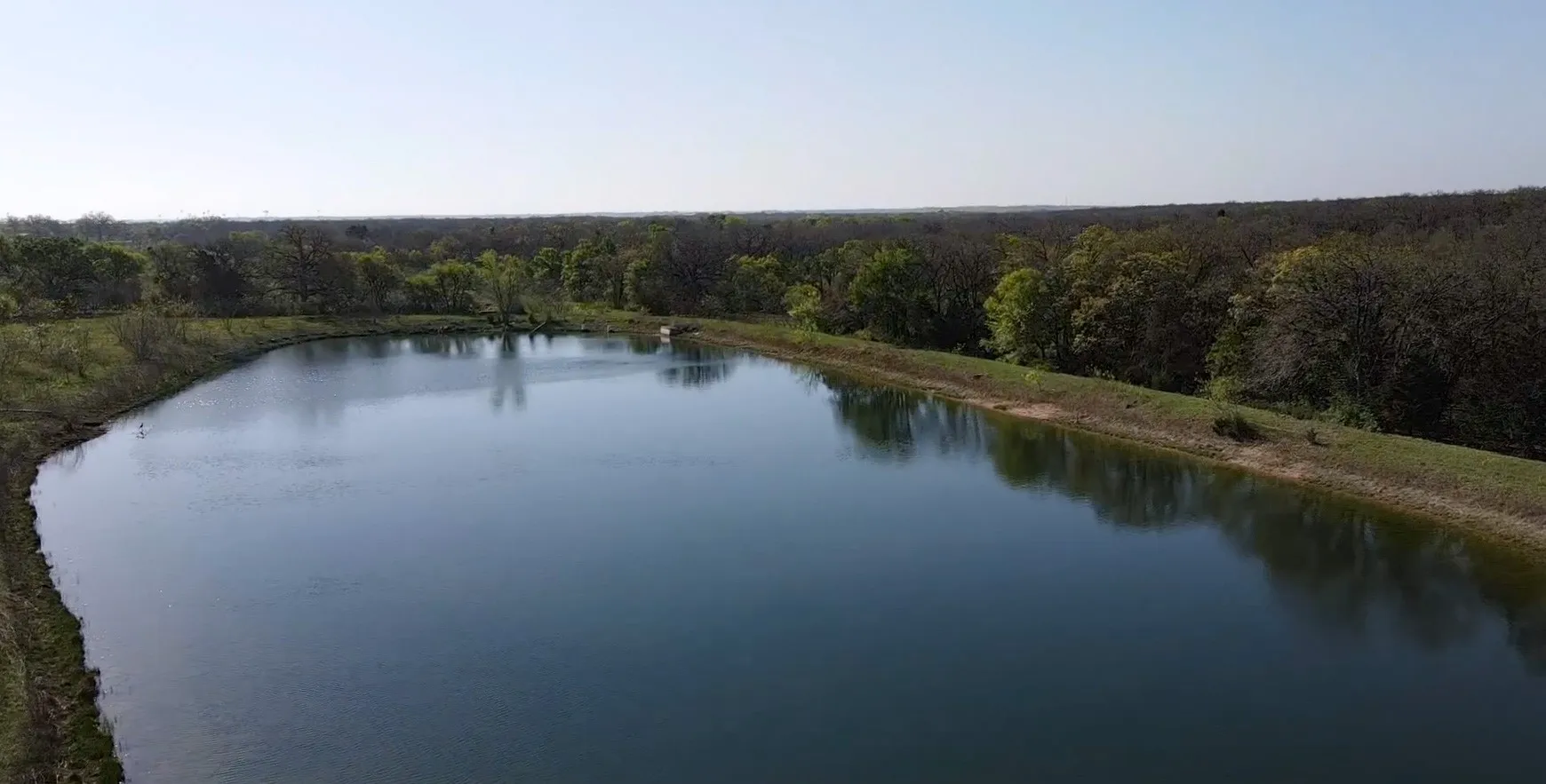 Water view with a heavily wooded area