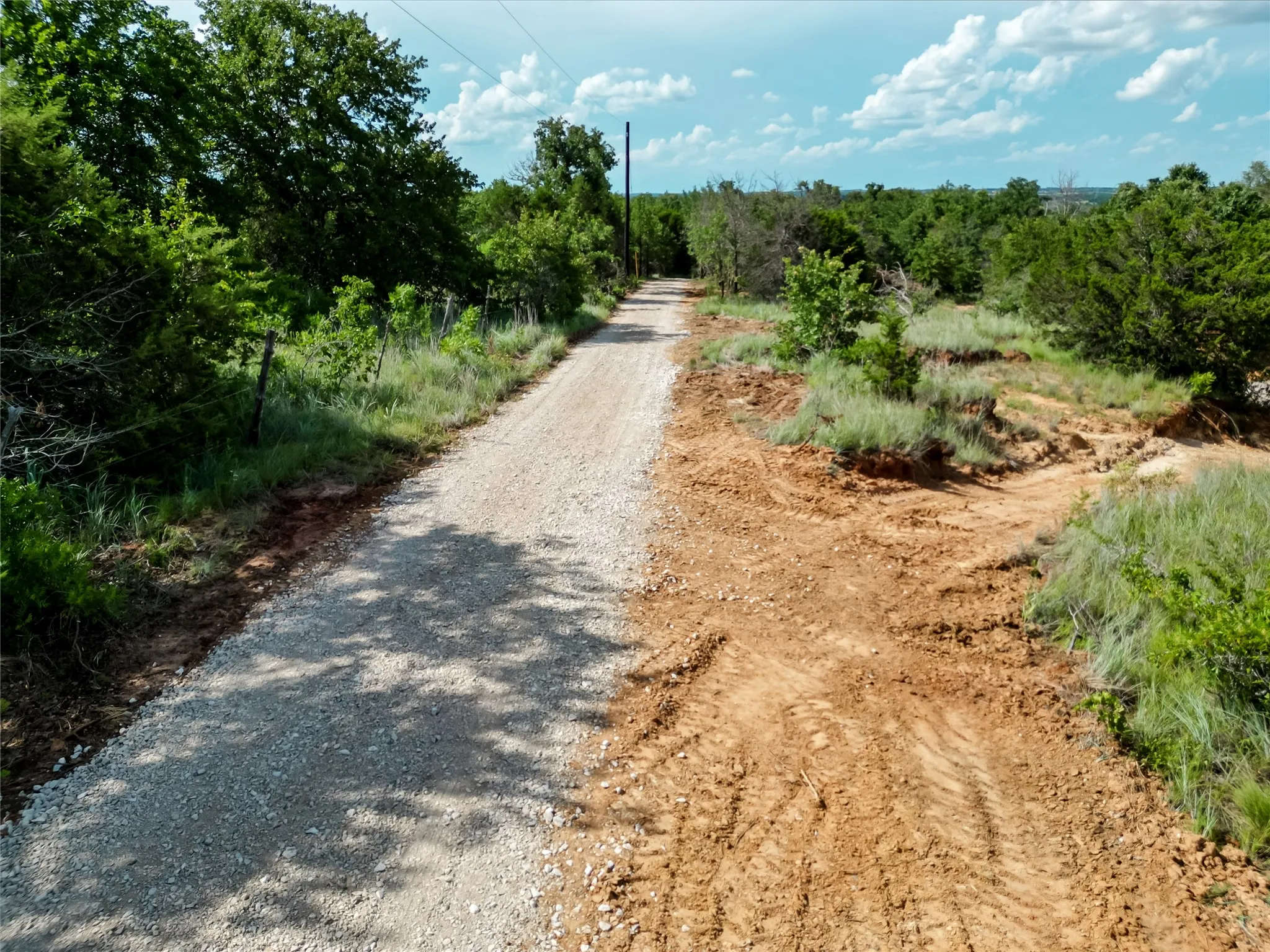 View of dirt / gravel road with a view of countryside