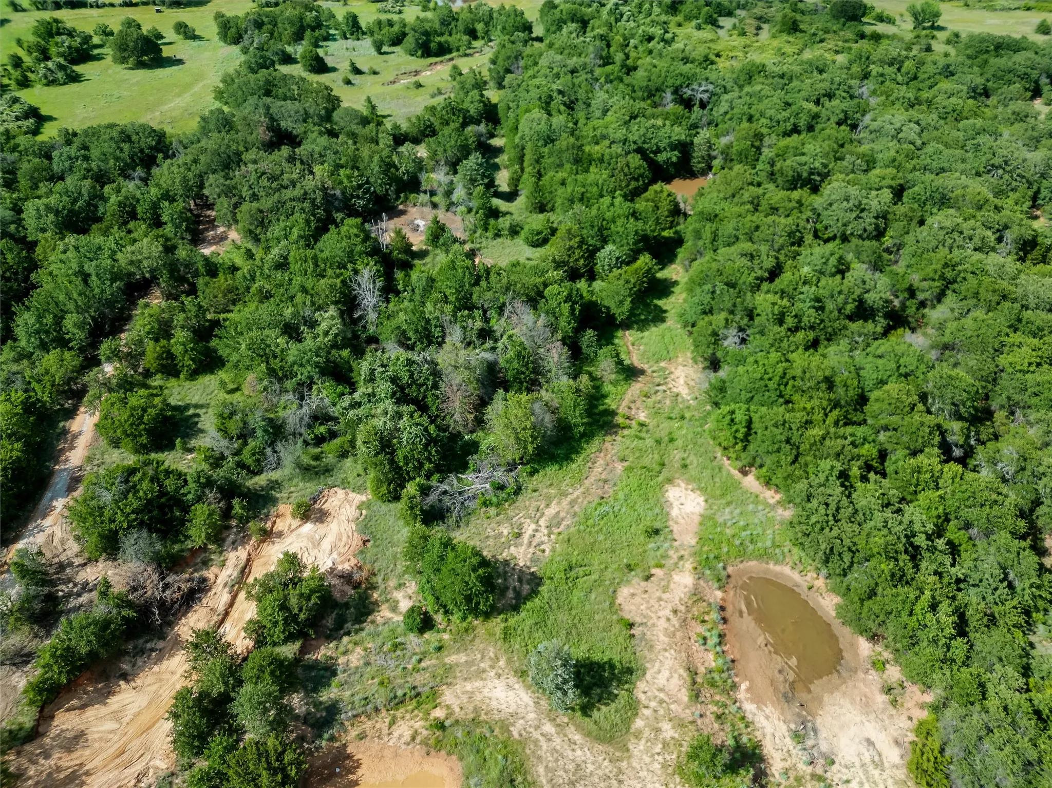 Aerial view of property and surrounding area with a forest