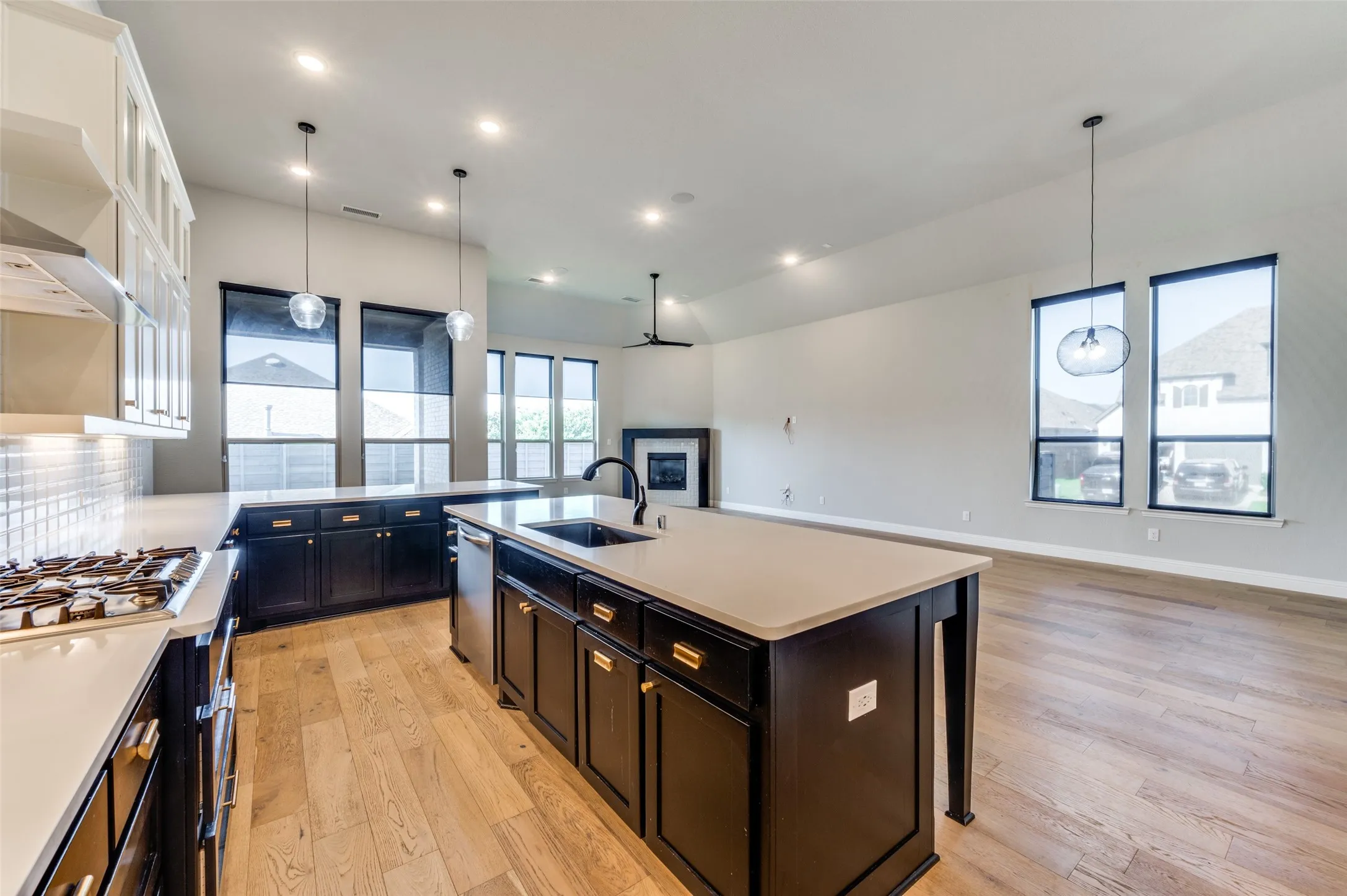 Kitchen with stainless steel appliances, light countertops, light wood-type flooring, a breakfast bar area, and hanging light fixtures
