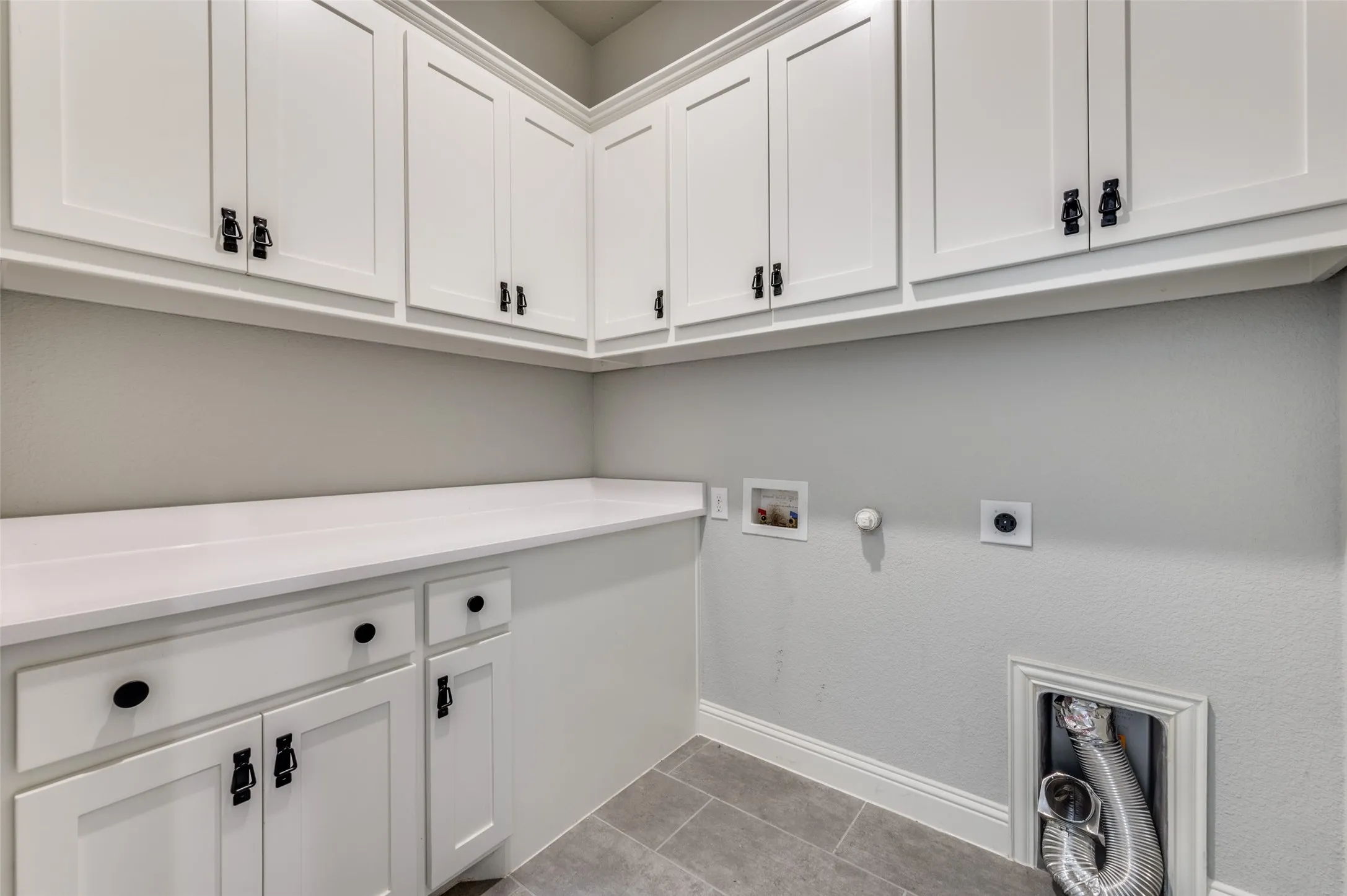 Washroom featuring cabinet space, electric dryer hookup, hookup for a washing machine, hookup for a gas dryer, and tile patterned flooring