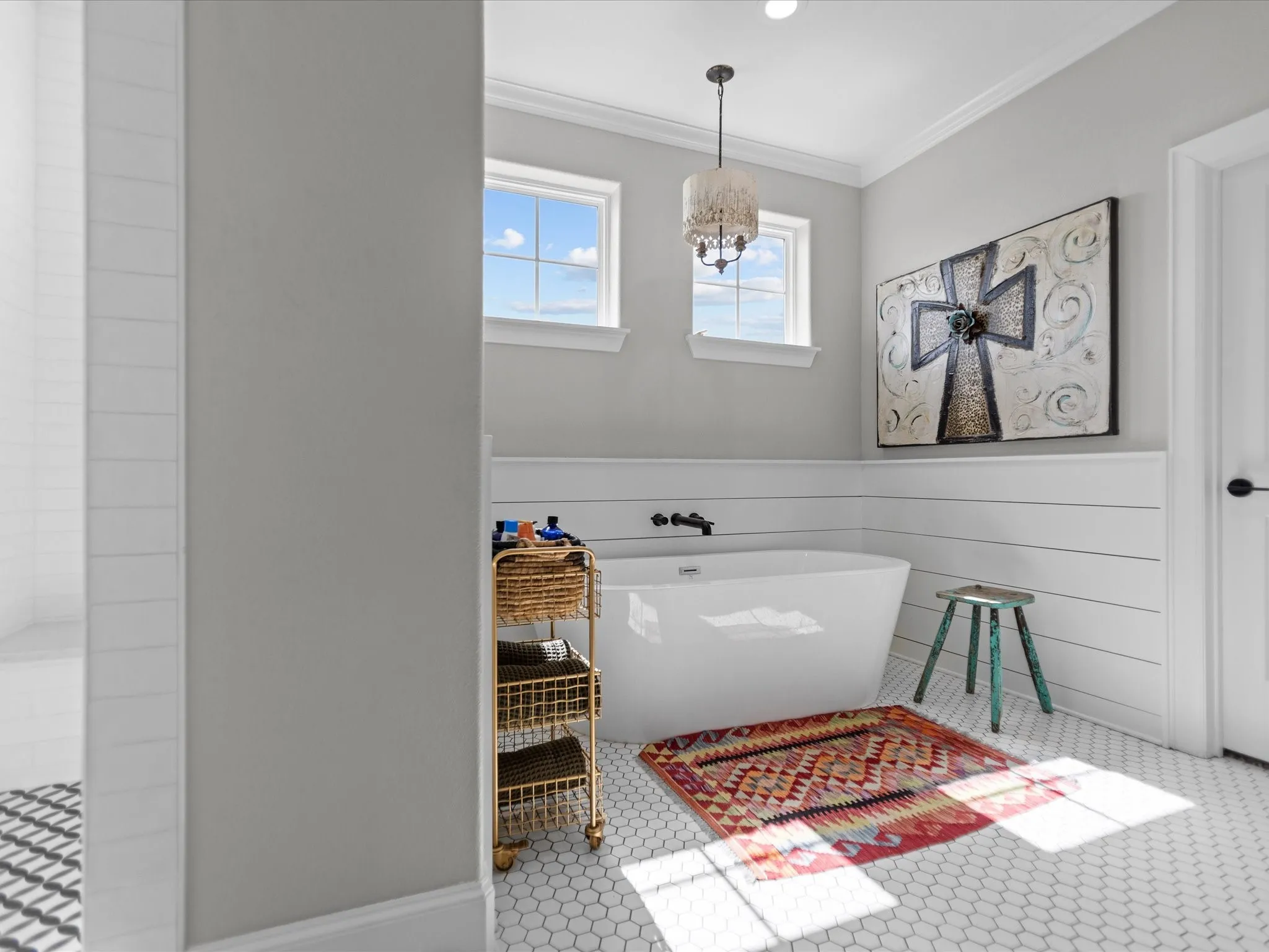 Full bath featuring ornamental molding, a freestanding bath, and a chandelier