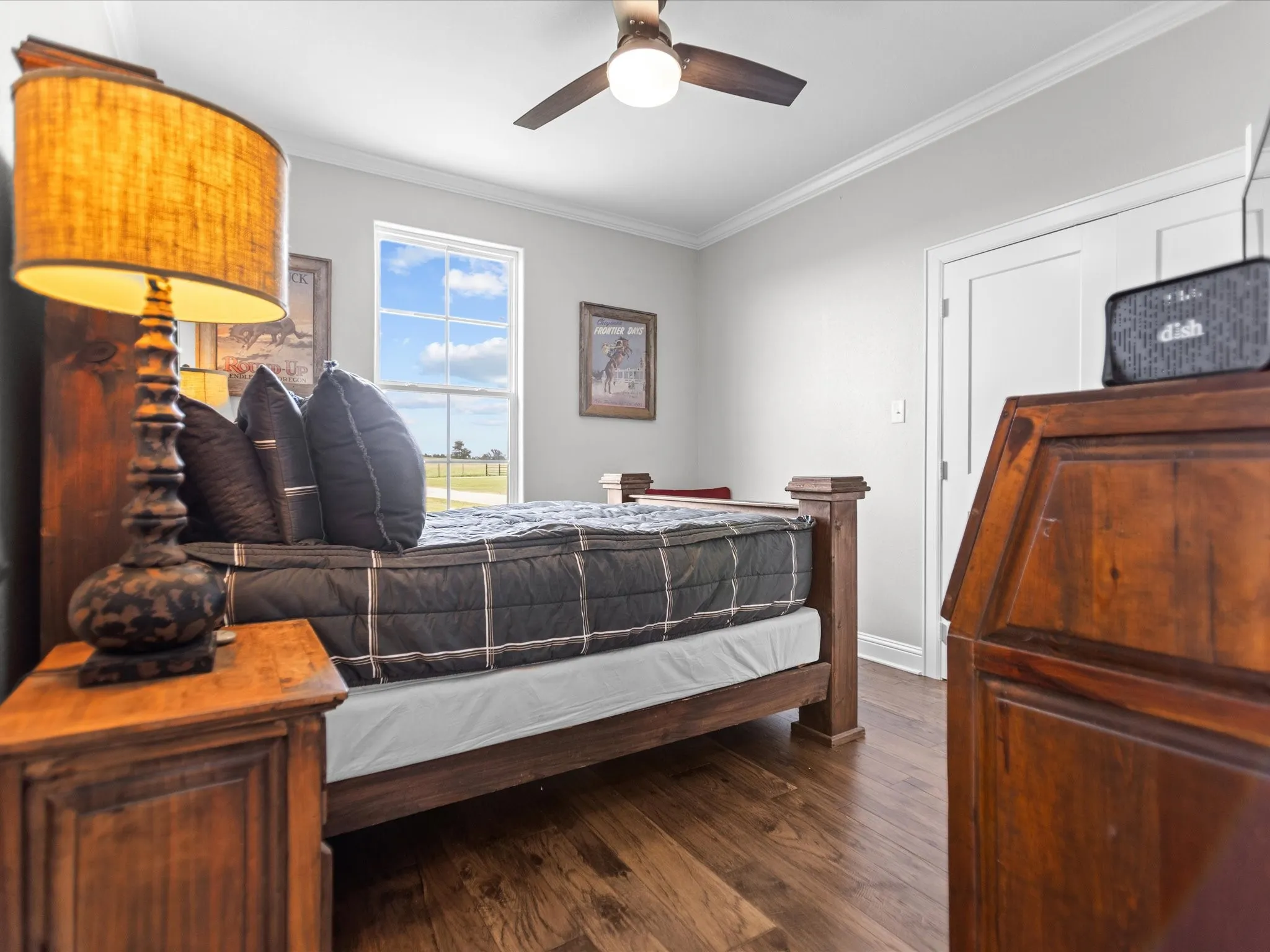 Bedroom featuring ornamental molding, dark wood-style flooring, and a ceiling fan
