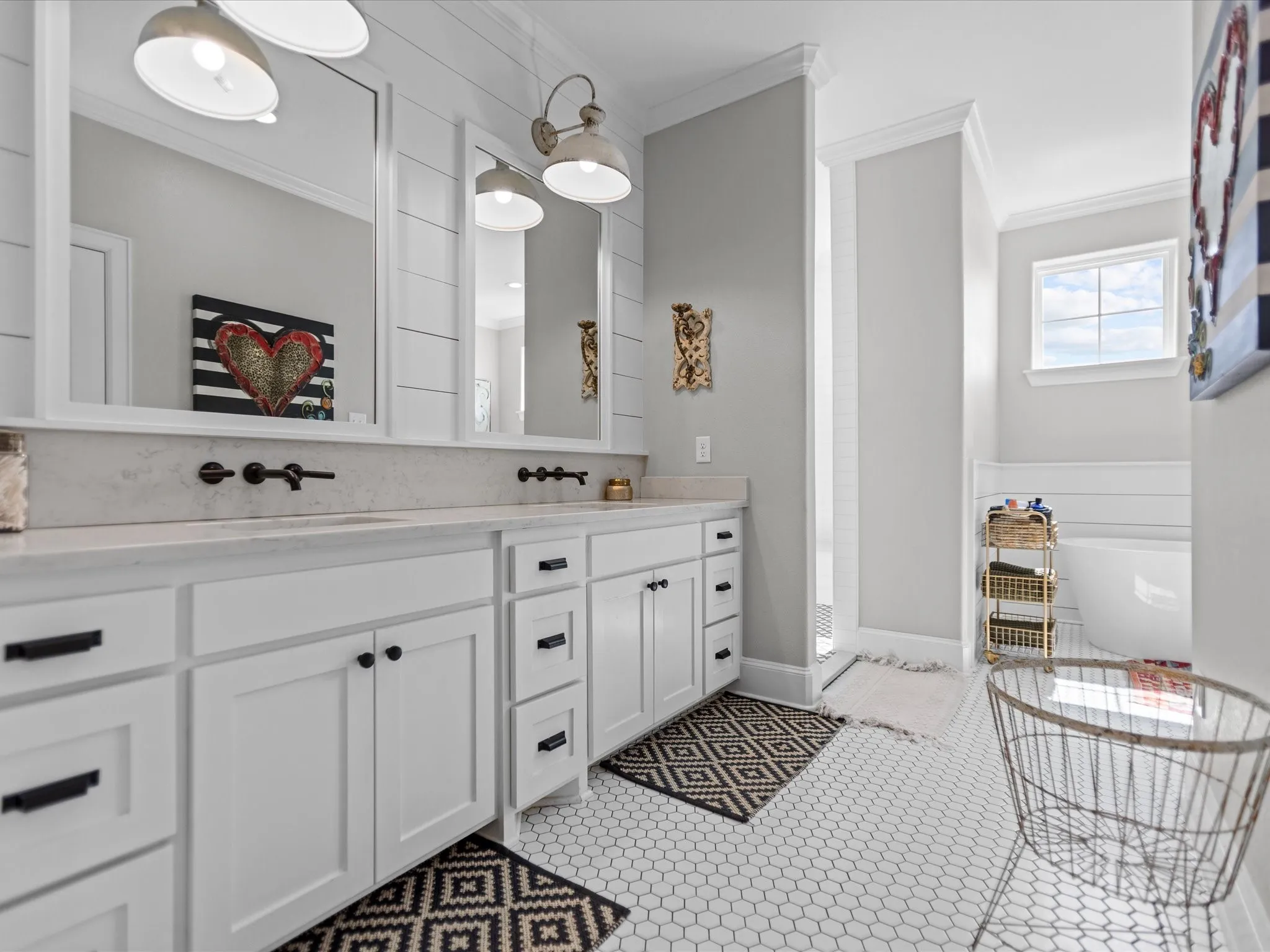 Full bathroom with crown molding, double vanity, a freestanding tub, and tile patterned flooring