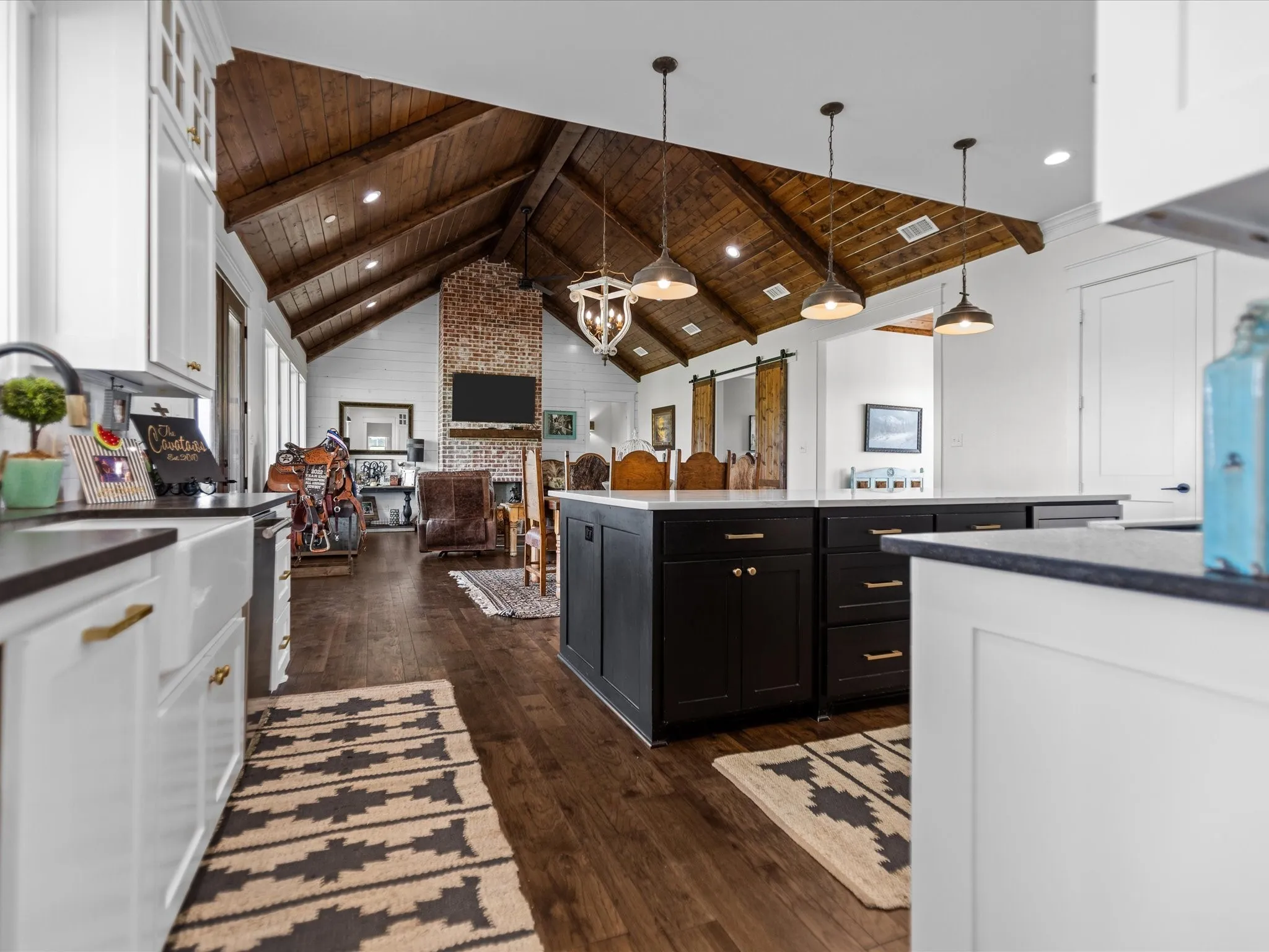 Kitchen featuring wooden ceiling, white cabinetry, dark cabinets, dark wood-style flooring, and a barn door