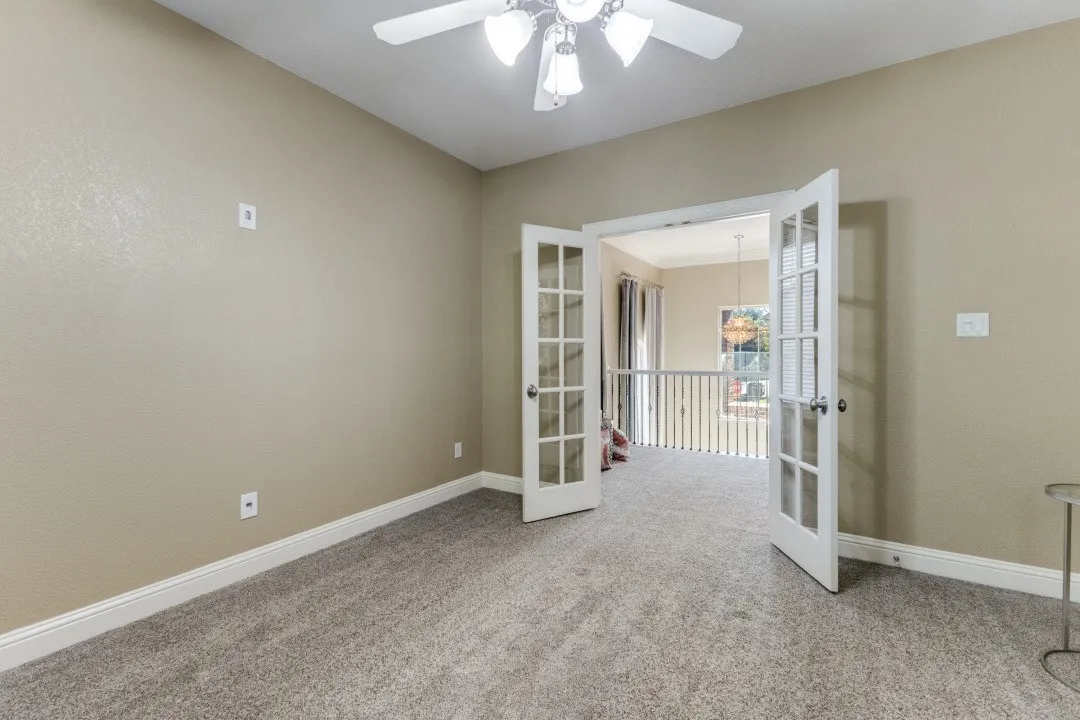 Spare room with light carpet and a ceiling fan