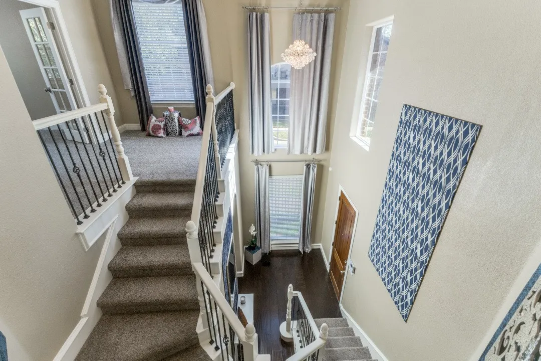 Stairway with plenty of natural light, a chandelier, and a towering ceiling