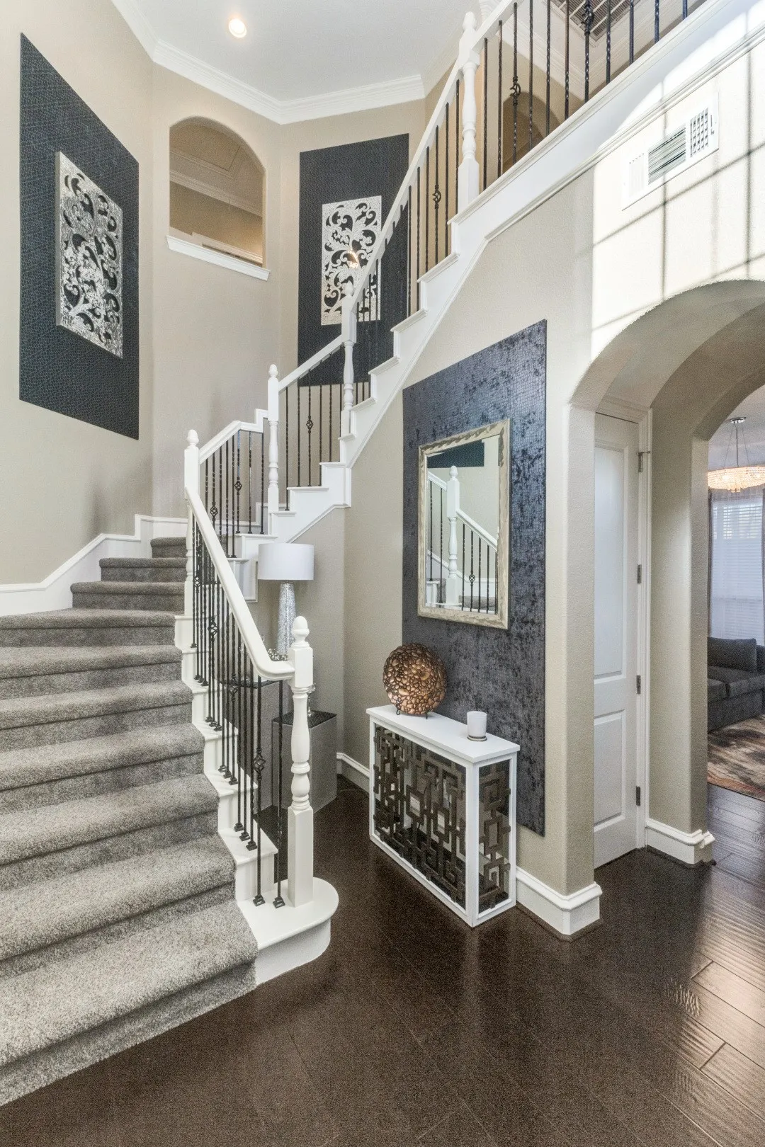Stairs featuring arched walkways, crown molding, and a high ceiling
