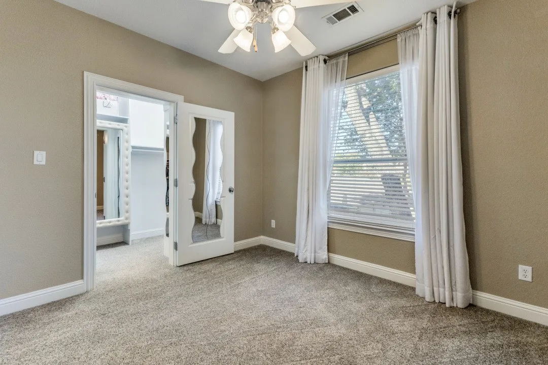 Spare room with light carpet and a ceiling fan